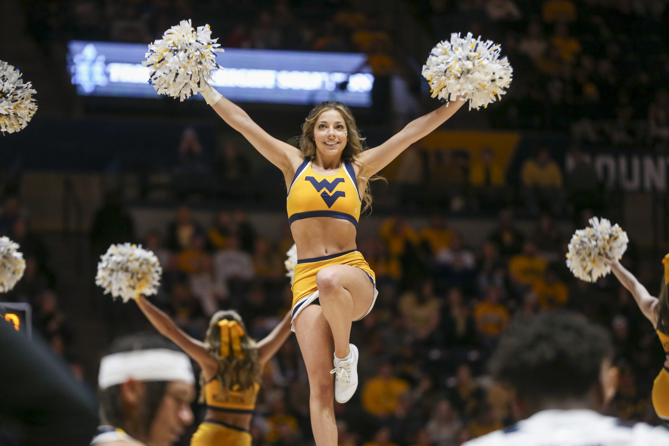 Jan 20, 2024; Morgantown, West Virginia, USA; A West Virginia Mountaineers cheerleader performs during the second half against the Kansas Jayhawks at WVU Coliseum. Mandatory Credit: Ben Queen-Imagn Images