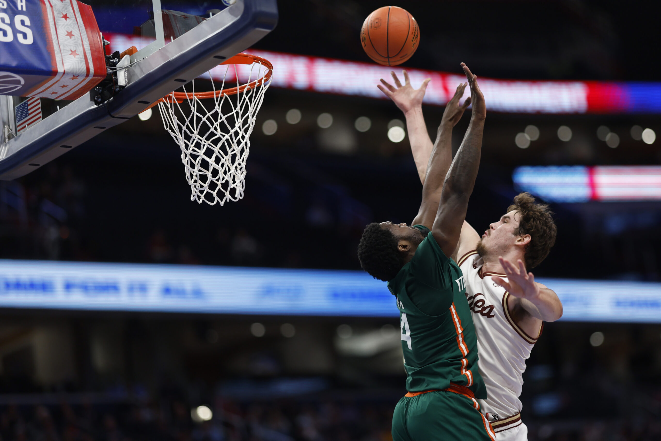 Mar 12, 2024; Washington, D.C., USA; Boston College Eagles forward Quinten Post (12) shoots the ball as Miami (Fl) Hurricanes guard Bensley Joseph (4) defends in the second half at Capital One Arena. Mandatory Credit: Geoff Burke-Imagn Images