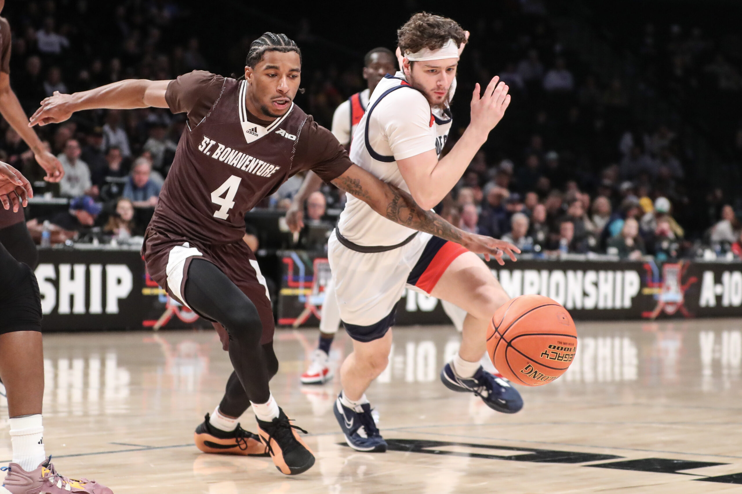 Mar 16, 2024; Brooklyn, NY, USA; St. Bonaventure Bonnies guard Moses Flowers (4) and Duquesne Dukes guard Jake DiMichele (44) fight for a loose ball in the first half at Barclays Center. Mandatory Credit: Wendell Cruz-Imagn Images