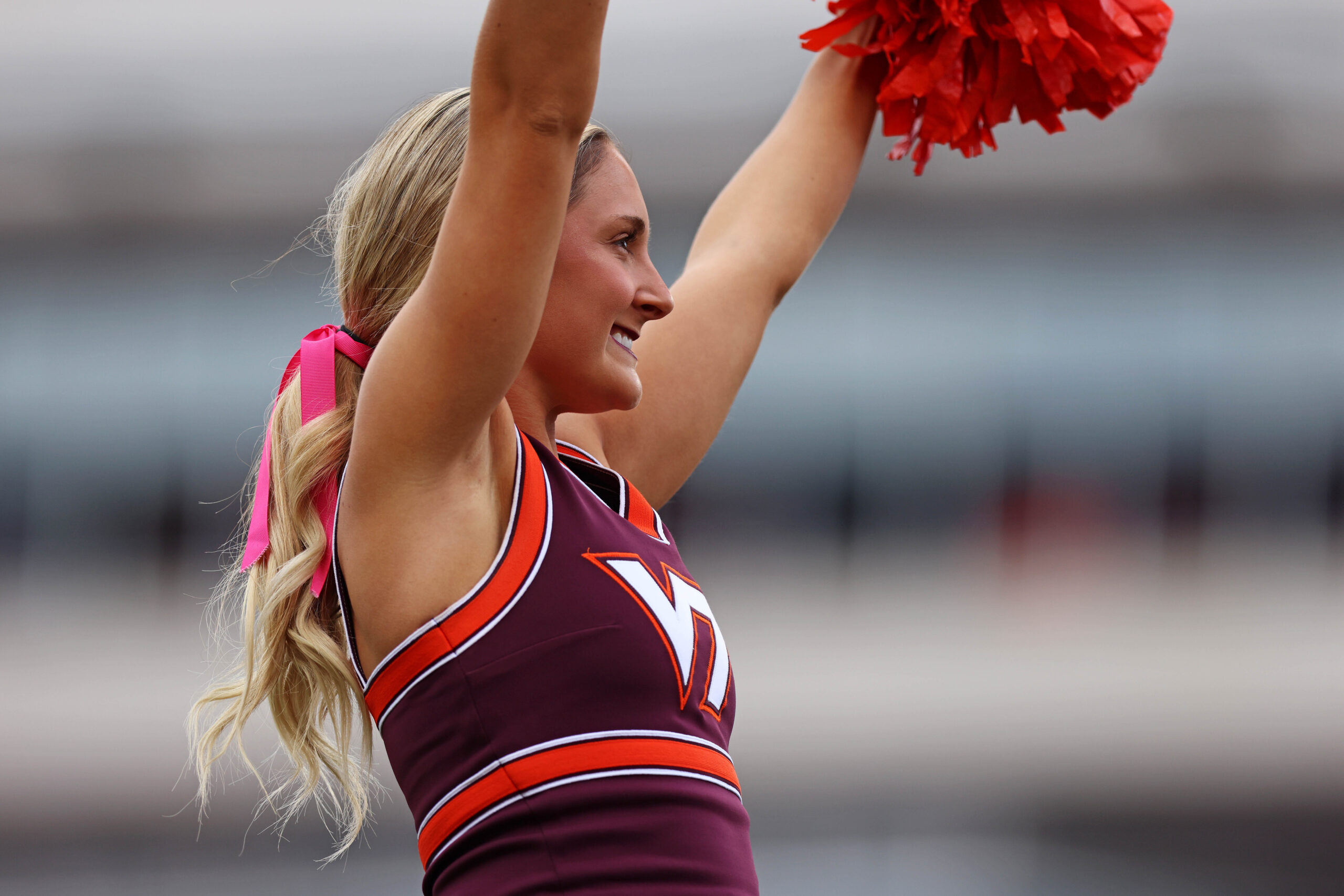 Oct 26, 2024; Blacksburg, Virginia, USA; A Virginia Tech Hokies cheerleader waves during a time out of the game between the Virginia Tech Hokies and the Georgia Tech Yellow Jackets at Lane Stadium. Mandatory Credit: Peter Casey-Imagn Images