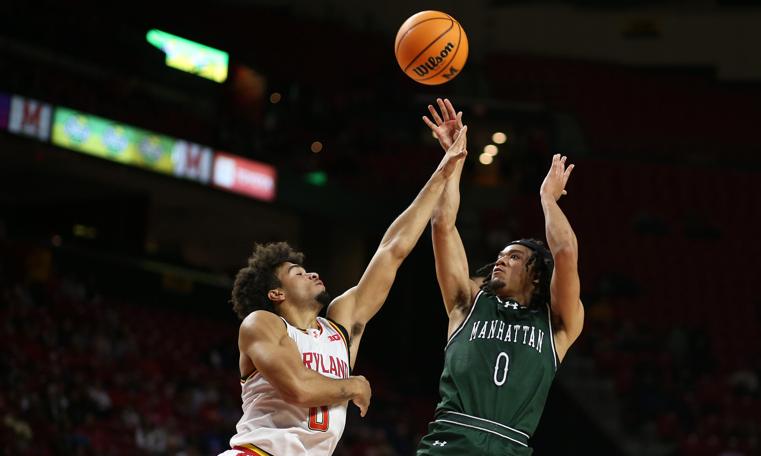 Nov 4, 2024; College Park, Maryland, USA; Manhattan Jaspers guard Devin Dinkins (0) shoots against Maryland Terrapins guard Ja'Kobi Gillespie (0) during the first half at Xfinity Center. Mandatory Credit: Daniel Kucin Jr.-Imagn Images