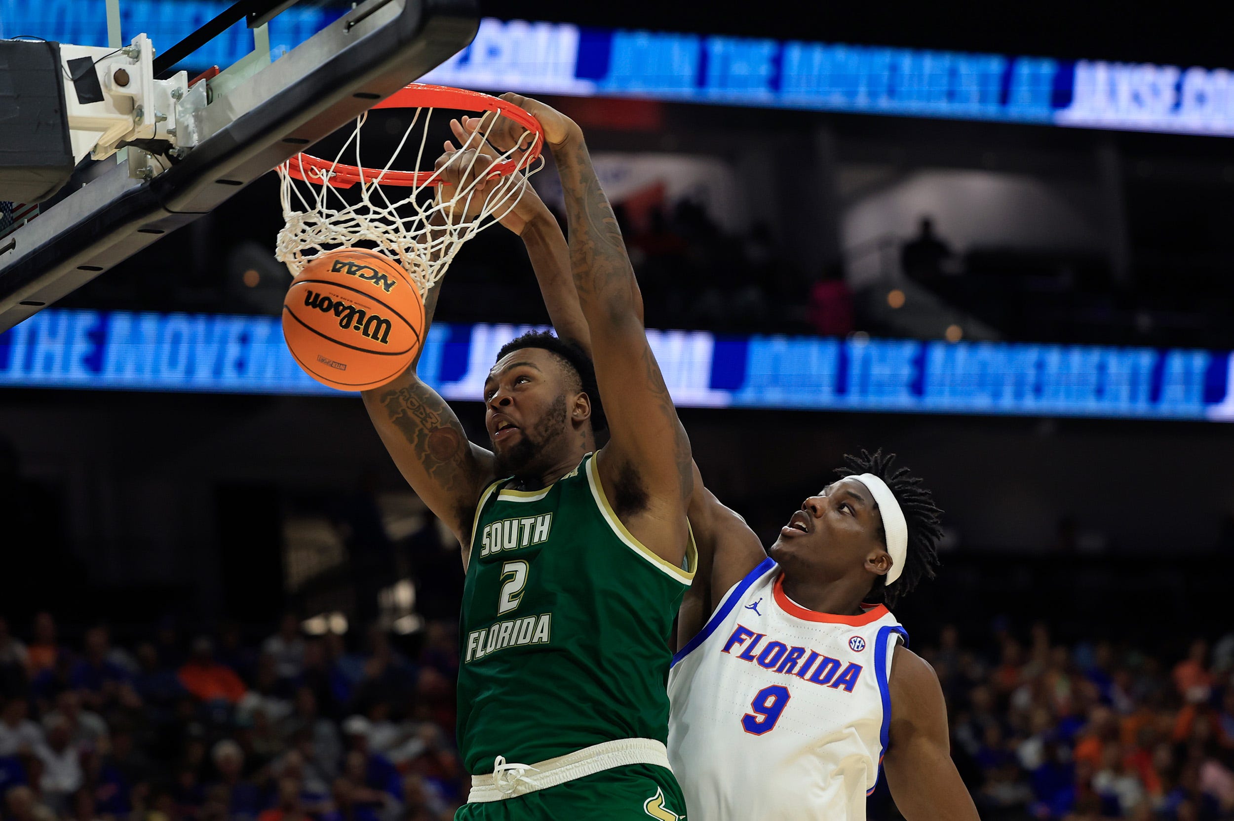 South Florida Bulls forward Jamille Reynolds (2) dunks on Florida Gators center Rueben Chinyelu (9) during the second half of an NCAA men’s basketball matchup Monday, Nov. 4, 2024 at VyStar Veterans Memorial Arena in Jacksonville, Fla. Florida defeated South Florida 98-83. [Corey Perrine/Florida Times-Union]