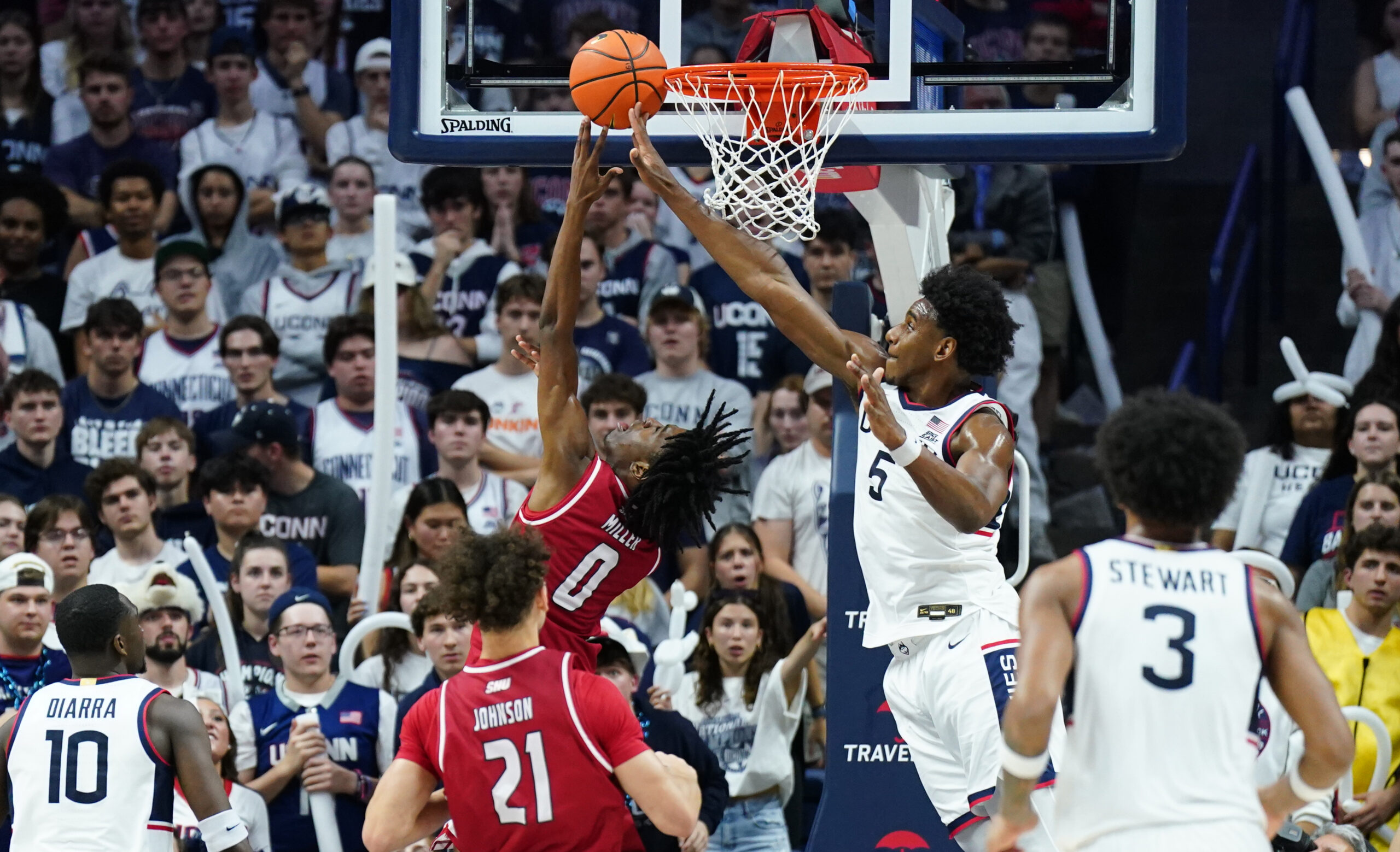 Nov 6, 2024; Storrs, Connecticut, USA; Sacred Heart Pioneers guard Keyishon Miller (0) makes the basket against Connecticut Huskies center Tarris Reed Jr. (5) in the second half at Harry A. Gampel Pavilion. Mandatory Credit: David Butler II-Imagn Images