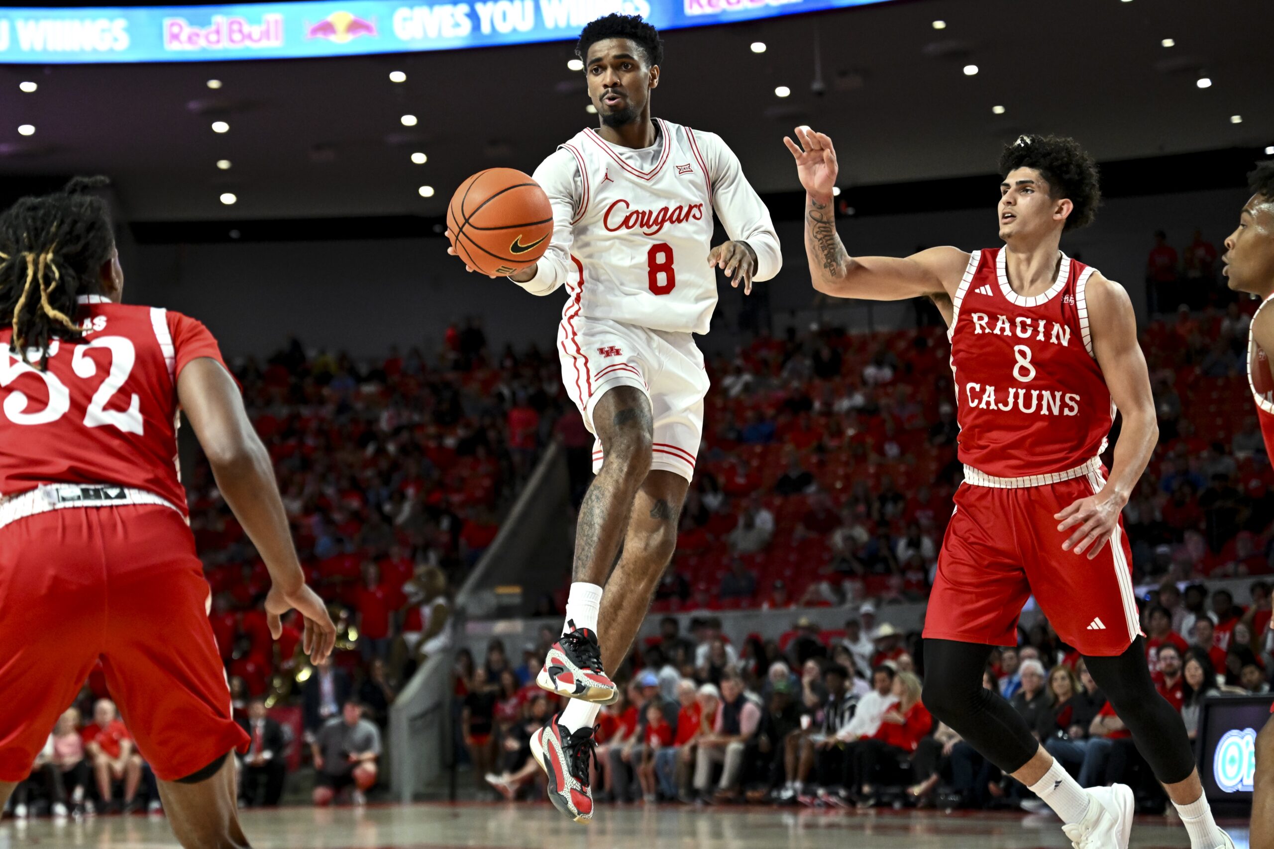 Nov 13, 2024; Houston, Texas, USA; Houston Cougars guard Mylik Wilson (8) looks to pass the ball as Louisiana Ragin Cajuns guard Mostapha El Moutaouakkil (8) defends during the second half at Fertitta Center. The Cougars defeated the Ragin Cajuns 91-45. Mandatory Credit: Maria Lysaker-Imagn Images