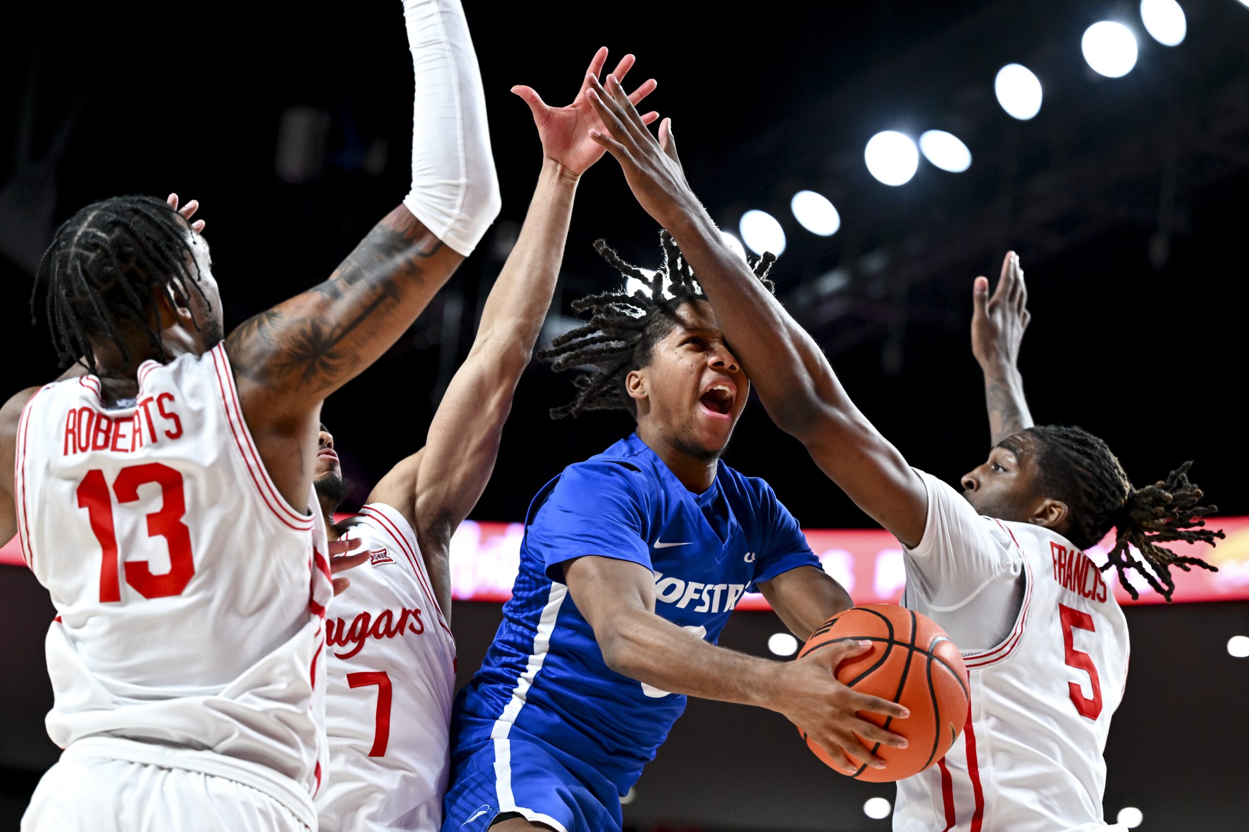 Nov 22, 2024; Houston, Texas, USA; Houston Cougars forward Ja'Vier Francis (5) fouls Hofstra Pride guard KiJan Robinson (0) during the first half at Fertitta Center. Mandatory Credit: Maria Lysaker-Imagn Images