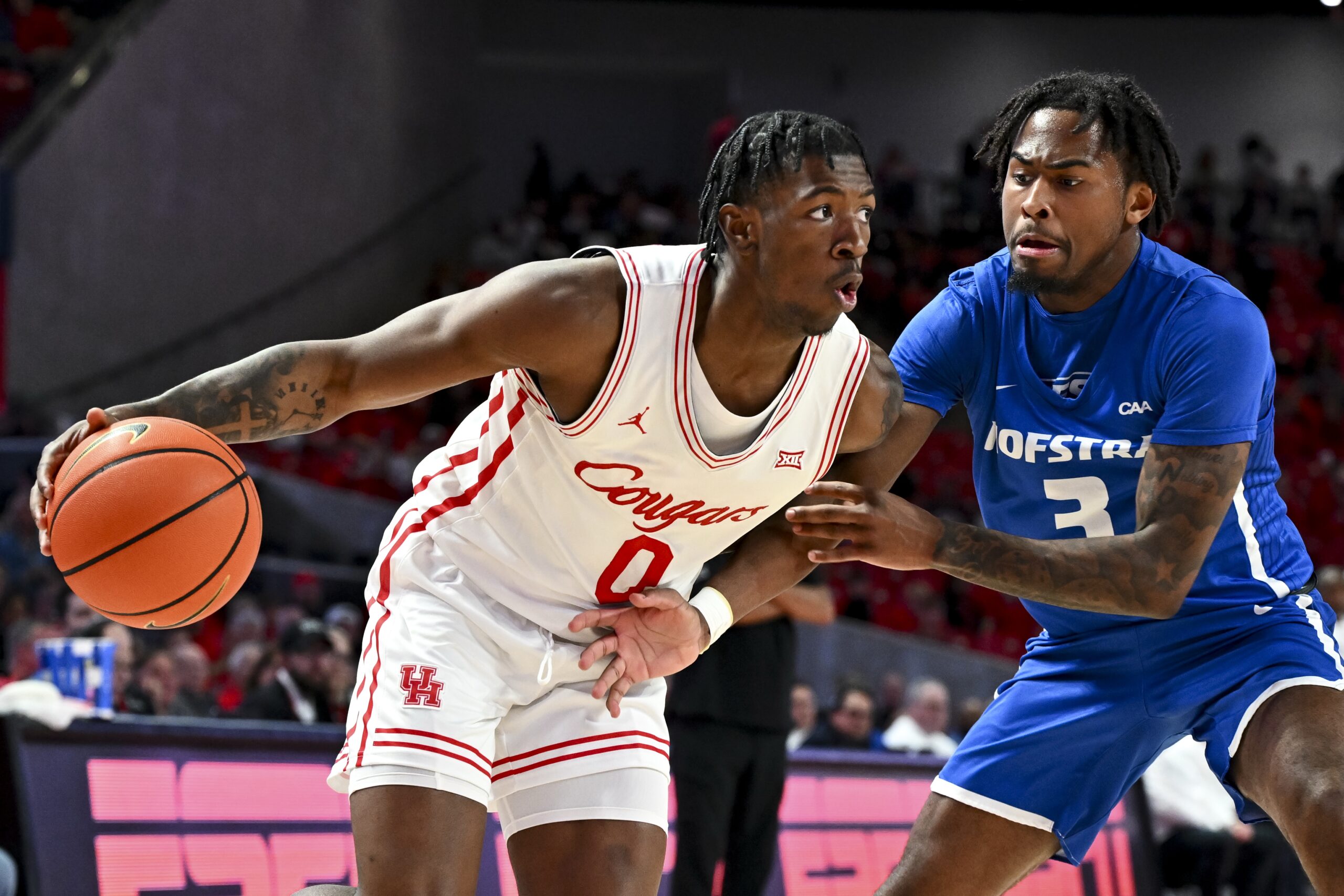 Nov 22, 2024; Houston, Texas, USA; Houston Cougars guard Kordelius Jefferson (0) drives against Hofstra Pride guard Khalil Farmer (3) during the second half at Fertitta Center. Mandatory Credit: Maria Lysaker-Imagn Images