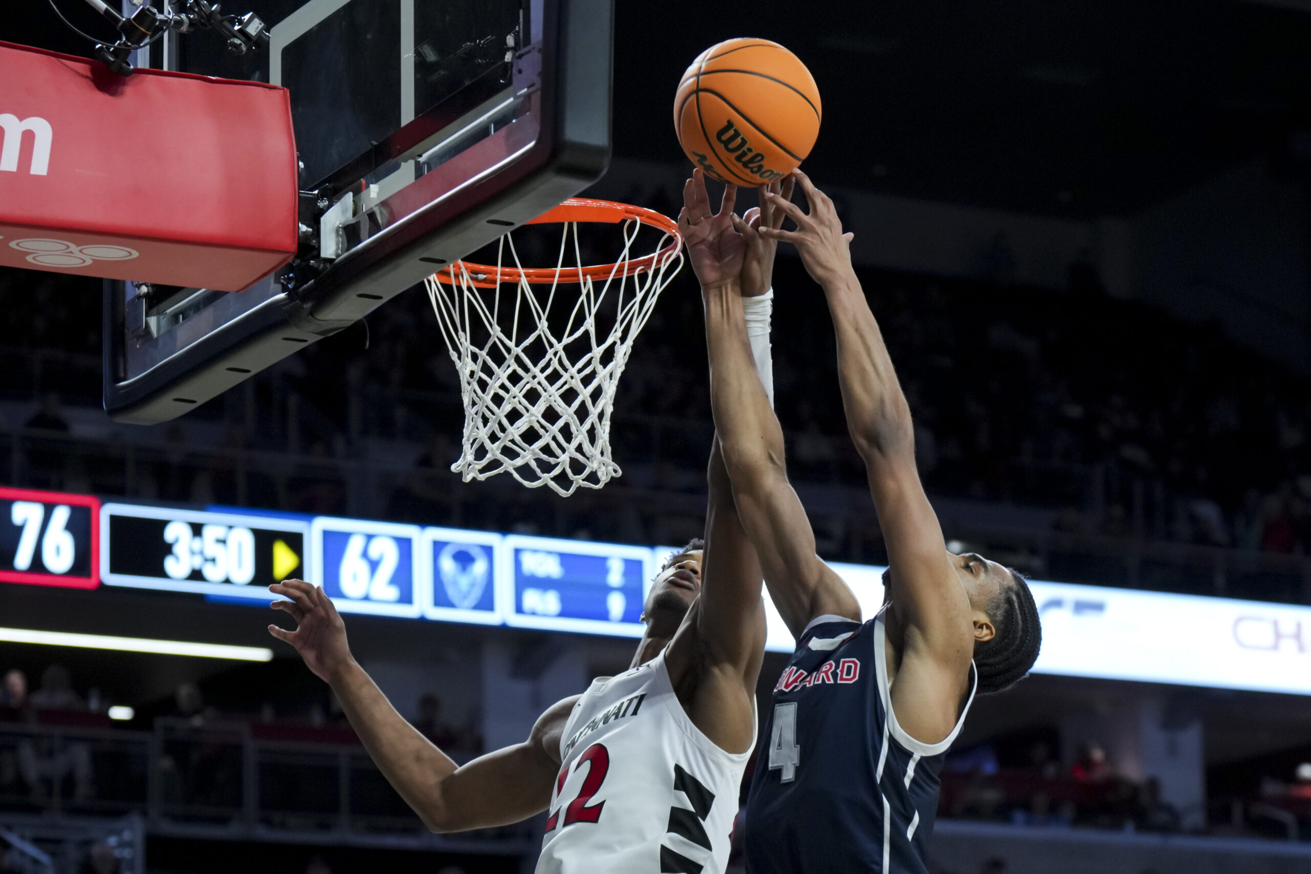 Dec 8, 2024; Cincinnati, Ohio, USA; Cincinnati Bearcats forward Arrinten Page (22) battles for a rebound against Howard Bison forward Miles Stewart (4) in the second half at Fifth Third Arena. Mandatory Credit: Aaron Doster-Imagn Images