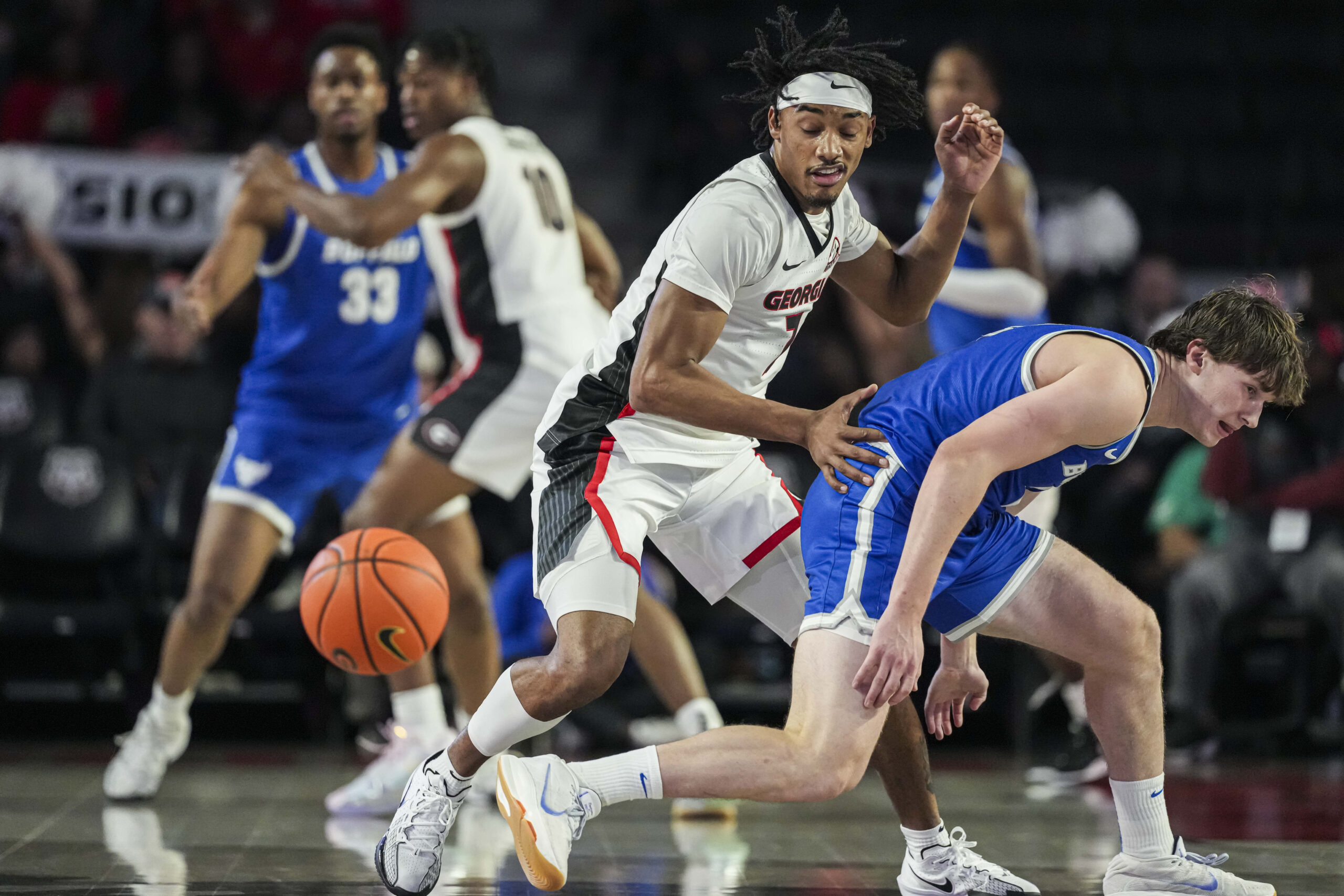 Dec 19, 2024; Athens, Georgia, USA; Georgia Bulldogs guard Tyrin Lawrence (7) steals the ball from Buffalo Bulls guard Ryan Sabol (2) at Stegeman Coliseum. Mandatory Credit: Dale Zanine-Imagn Images
