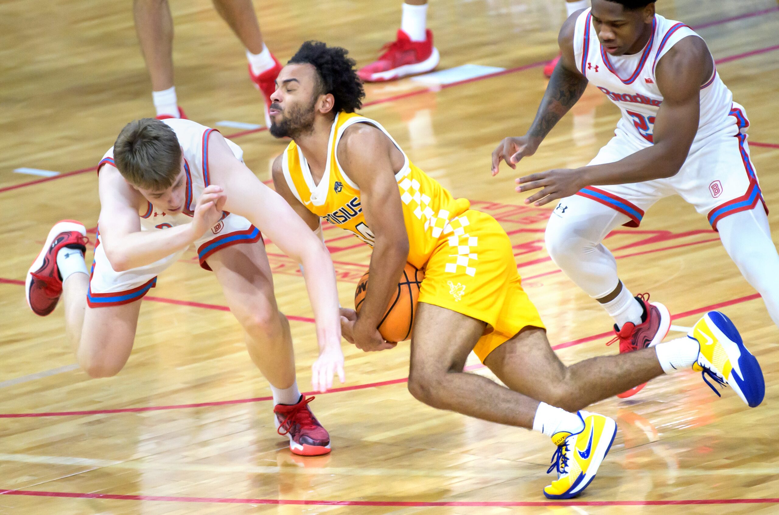 Bradley’s Almar Atlason, left, and Canisius’ Paul McMillan IV collide while chasing a loose ball in the first half of their college basketball game Saturday, Dec. 21, 2024 at Carver Arena. The Braves routed the Golden Griffins 92-59.
