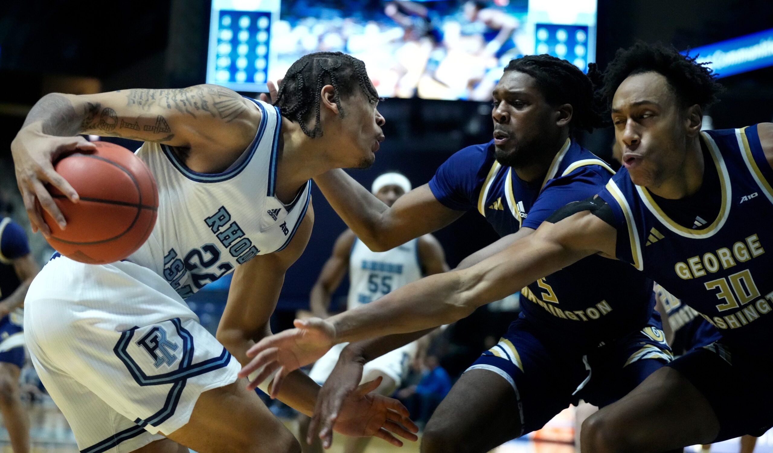 Rams forward Tyonne Farrell runs in to a wall of Revolutionaries, Gerald Drumgoole Jr. and form PC Friar, Rafael Castro ,on his way to the hoop in the first half.