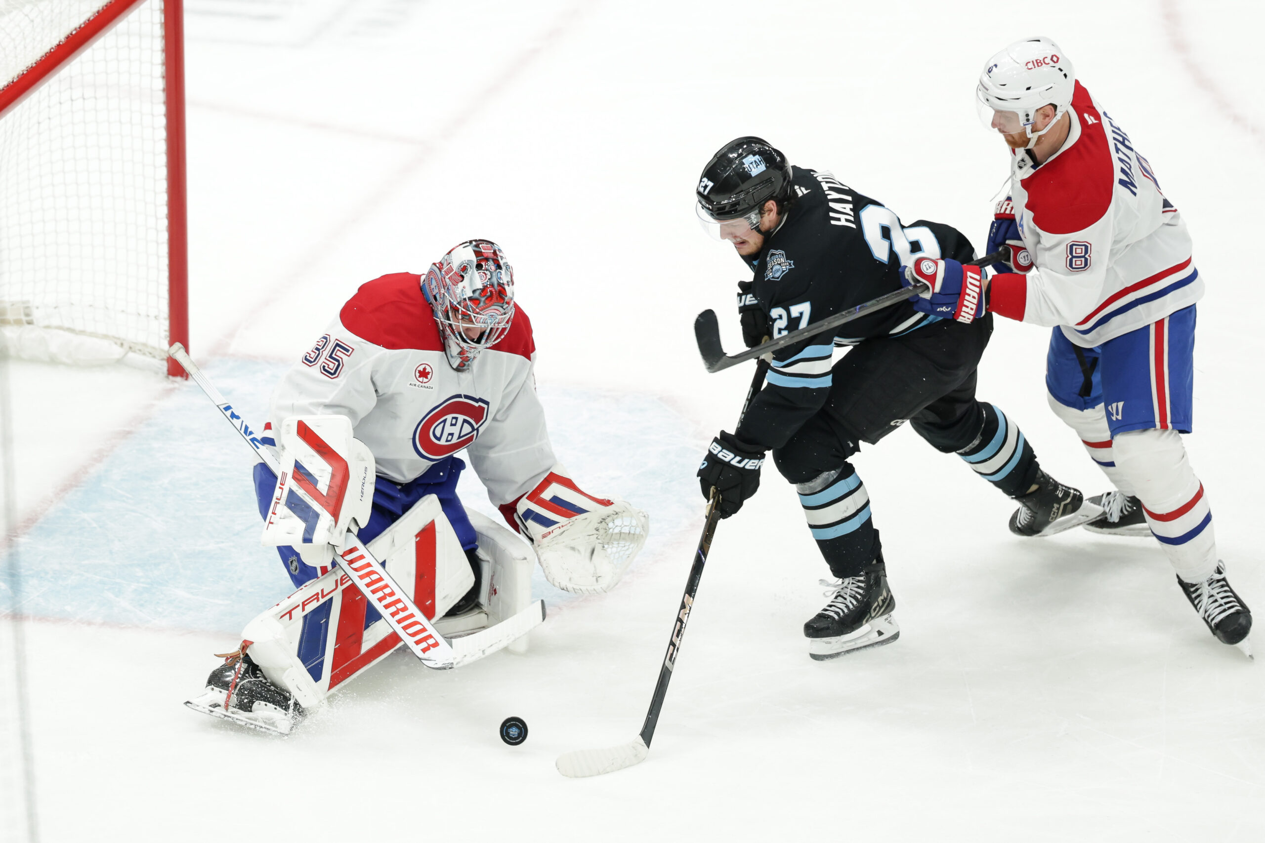 Jan 14, 2025; Salt Lake City, Utah, USA; Utah Hockey Club center Barrett Hayton (27) tries to push the puck past Montreal Canadiens goaltender Sam Montembeault (35) during the second period at Delta Center. Mandatory Credit: Chris Nicoll-Imagn Images