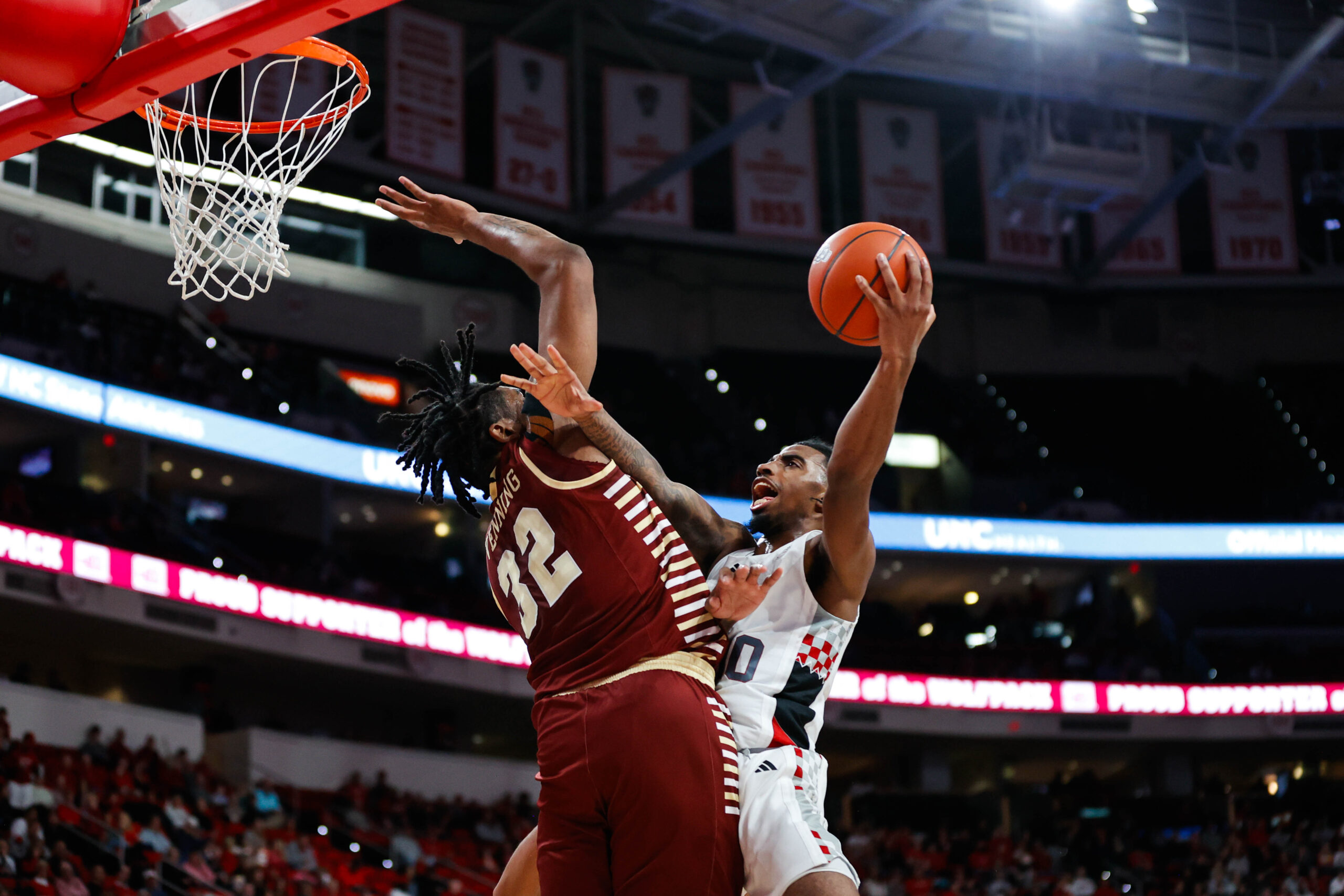 Feb 15, 2025; Raleigh, North Carolina, USA; North Carolina State Wolfpack guard Marcus Hill (10) attempts to put the ball past Boston College Eagles forward Chad Venning (32) during the first half of the game at Lenovo Center. Mandatory Credit: Jaylynn Nash-Imagn Images