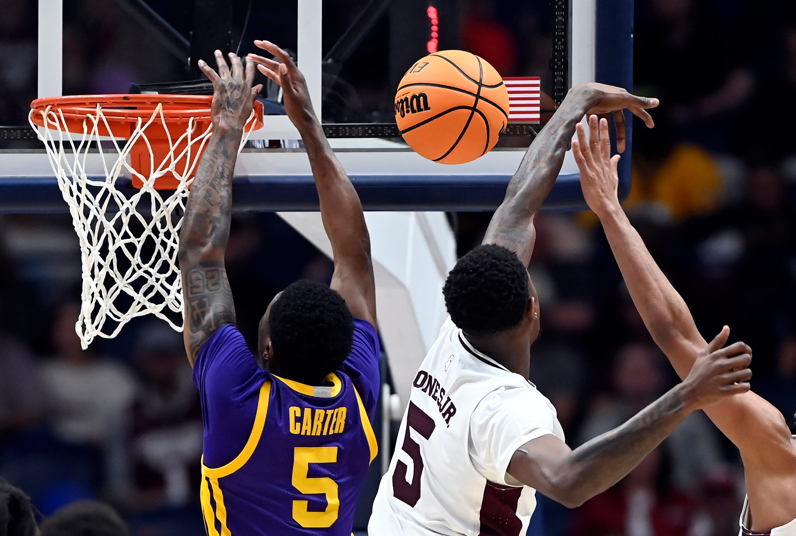 Mississippi State guard Shawn Jones Jr. (5) swats a shot by LSU guard Cam Carter (5) during a NCAA college basketball first round game at the men’s Southeastern Conference Tournament Wednesday, March 12, 2025, in Nashville, Tenn.