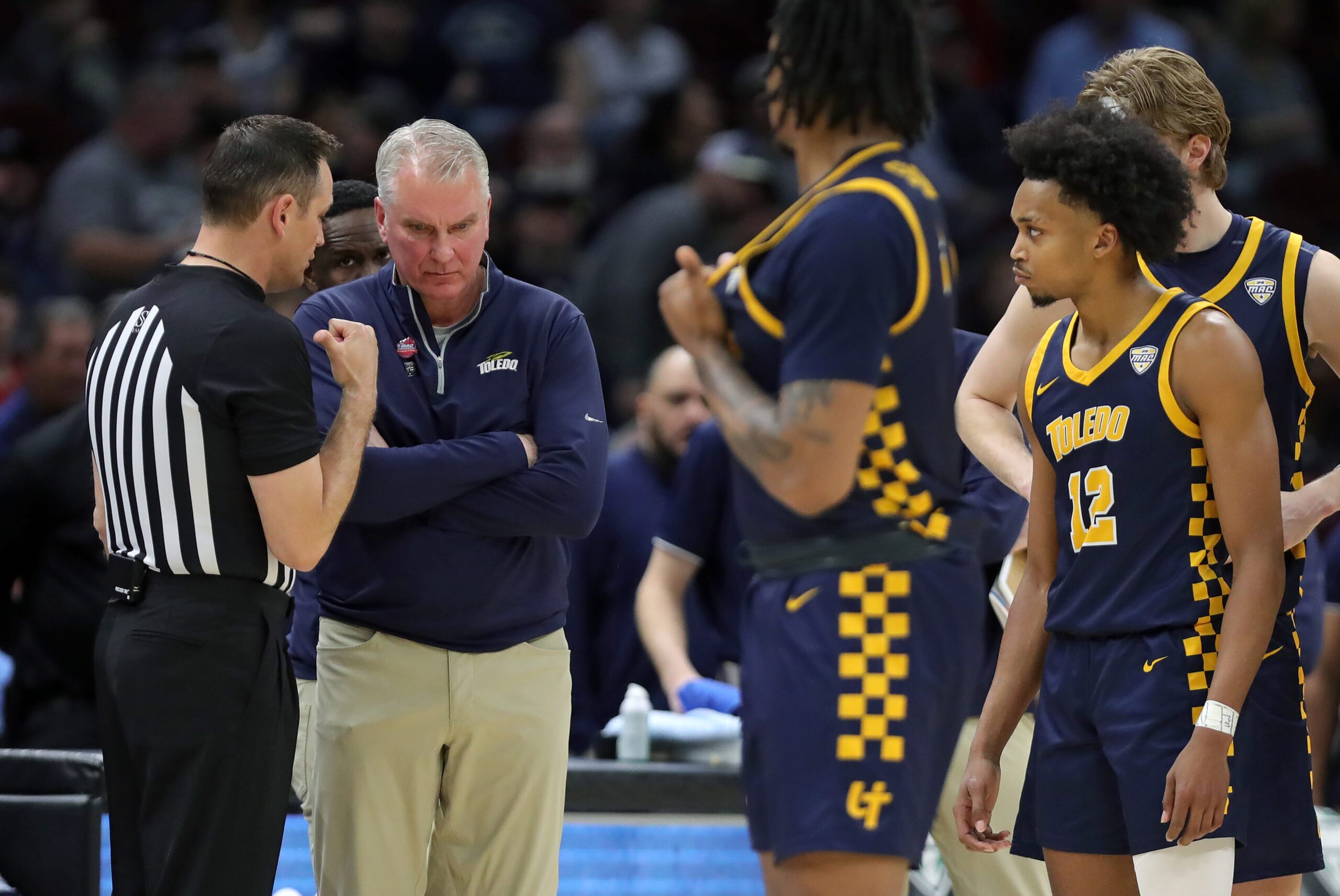 Toledo Rockets head coach Tod Kowalczyk receives an explanation from a referee after guard Seth Hubbard (12) was charged with a technical foul during the second half of an NCAA college basketball game in the semifinals of the Mid-American Conference Tournament at Rocket Arena on Friday, March 14, 2025, in Cleveland, Ohio.