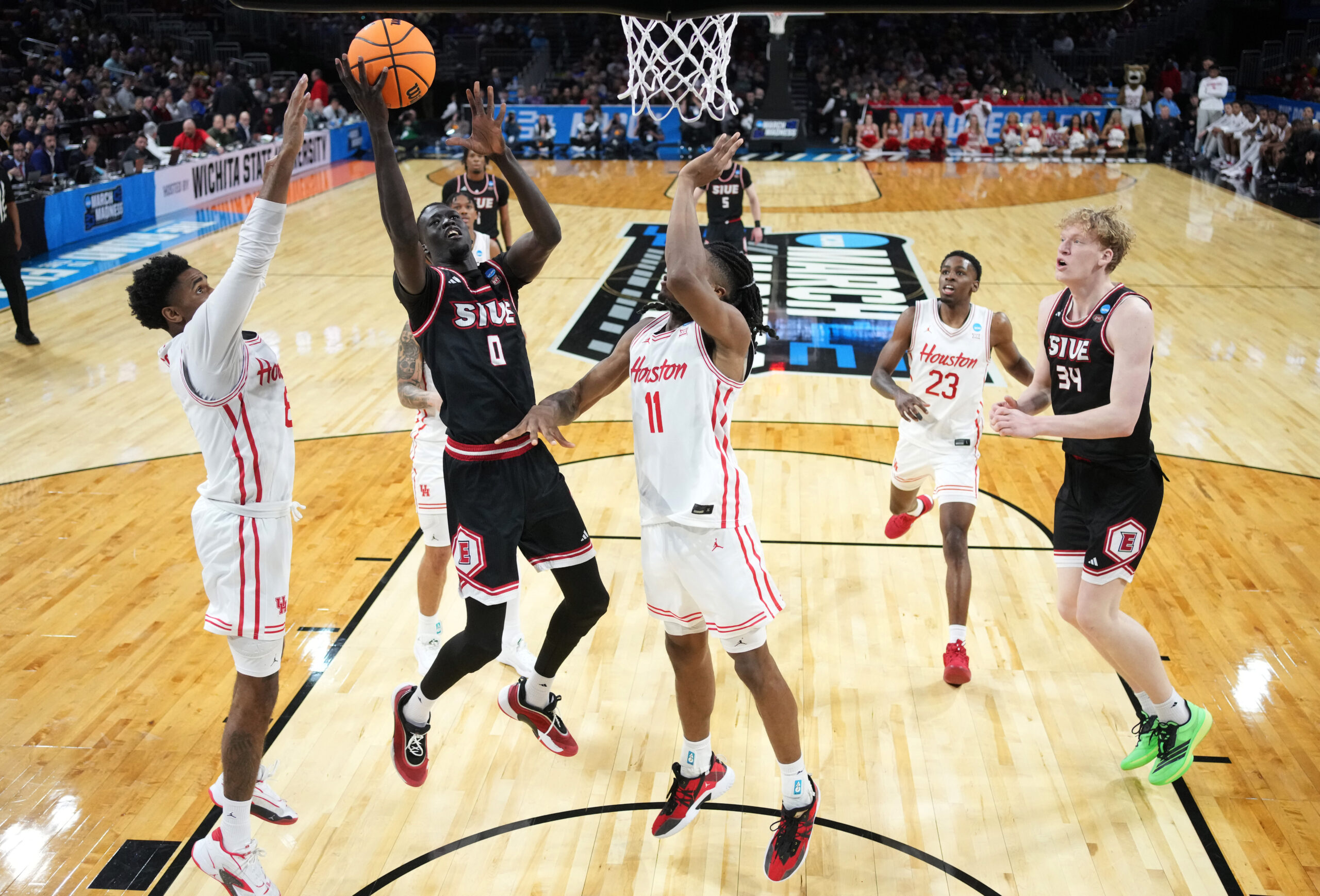 Mar 20, 2025; Wichita, KS, USA; SIU Edwardsville Cougars forward Ring Malith (0) shoots against Houston Cougars guard Mylik Wilson (8) and forward Joseph Tugler (11) in the second half of a first round men’s NCAA Tournament game at Intrust Bank Arena. Mandatory Credit: Kirby Lee-Imagn Images