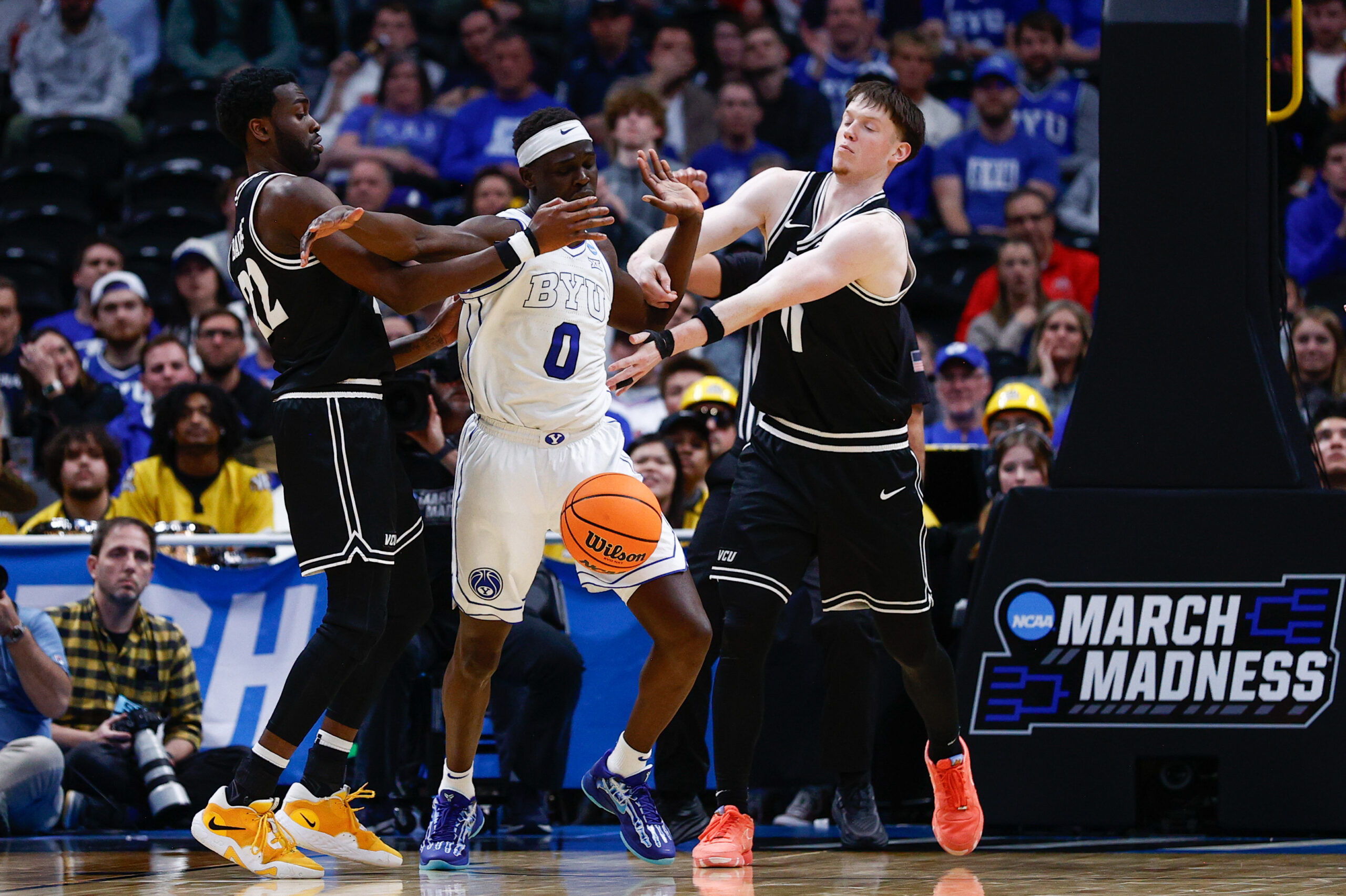Mar 20, 2025; Denver, CO, USA; Brigham Young Cougars forward Mawot Mag (0) battles for the ball with VCU Rams guard Joe Bamisile (22) and guard Max Shulga (11) during the second half in the first round of the NCAA Tournament at Ball Arena. Mandatory Credit: Isaiah J. Downing-Imagn Images