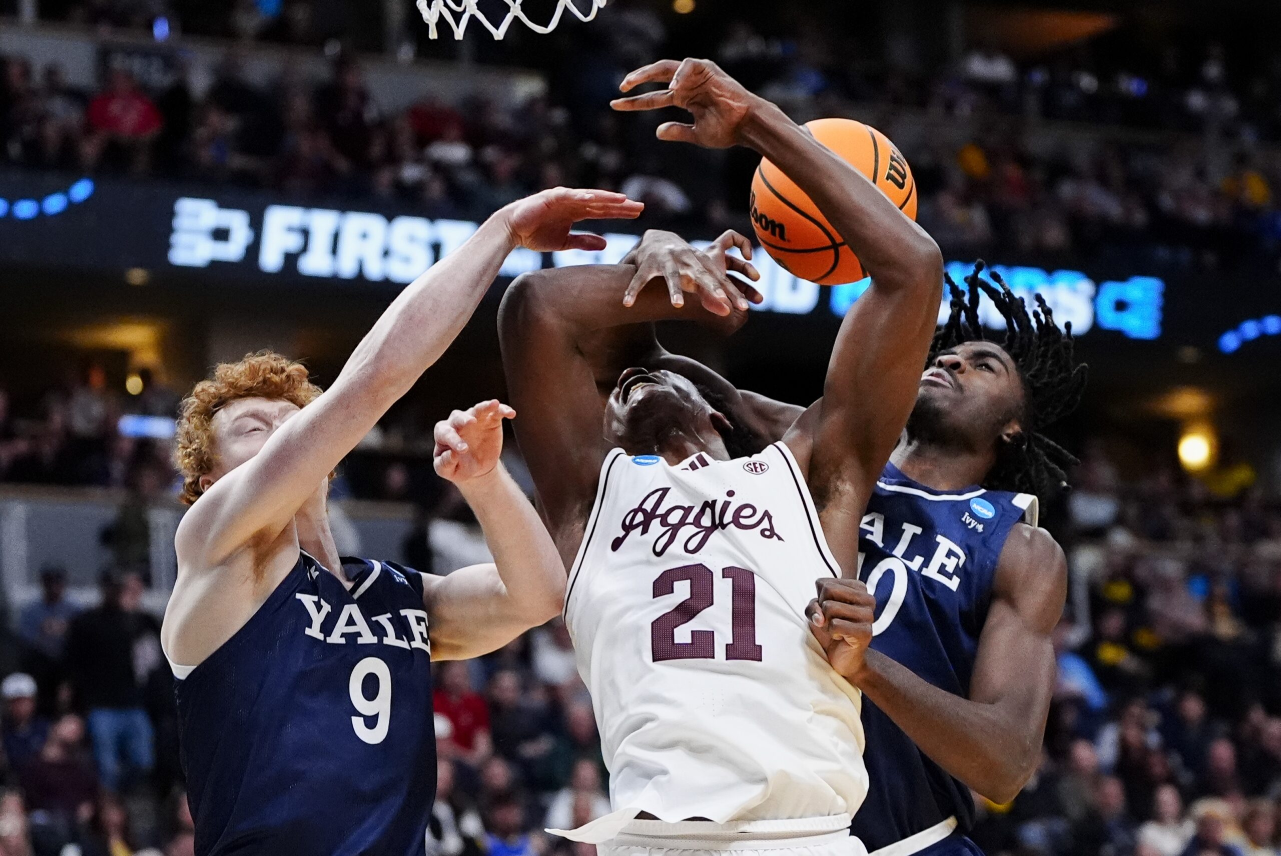 March 20, 2025; Denver, CO, USA; Texas A&M Aggies forward Pharrel Payne (21) is fouled by Yale Bulldogs center Samson Aletan (10) as forward Riley Fox (9) defends during the second half at Ball Arena. Mandatory Credit: Ron Chenoy-Imagn Images
