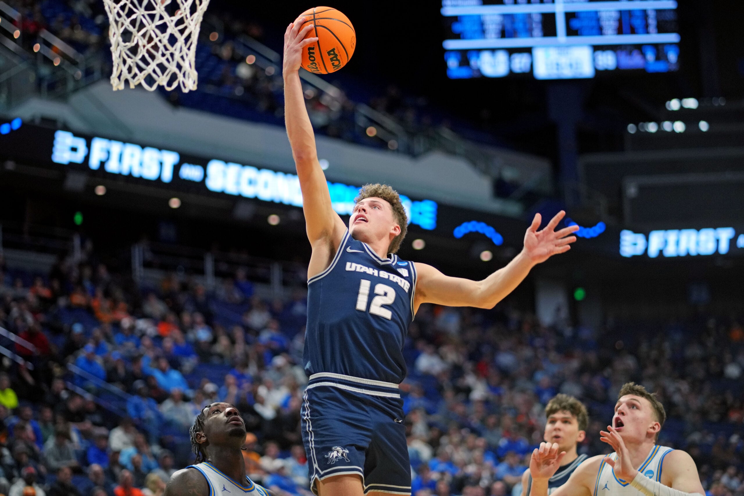 Mar 20, 2025; Lexington, KY, USA;  Utah State Aggies guard Mason Falslev (12) shoots the ball during the second half against the UCLA Bruins in the first round of the NCAA Tournament at Rupp Arena. Mandatory Credit: Aaron Doster-Imagn Images