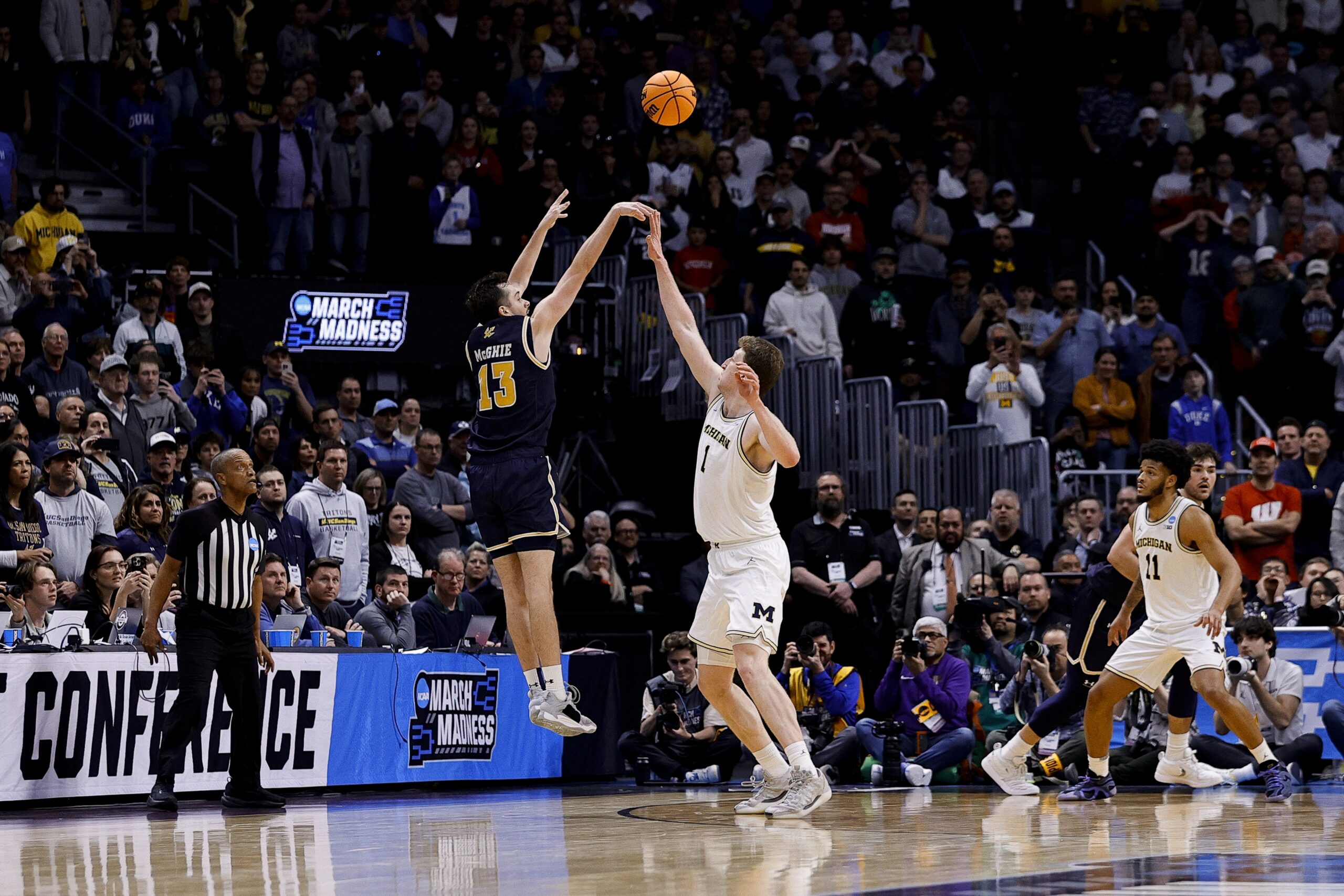 March 20, 2025; Denver, CO, USA; UC San Diego Tritons guard Tyler McGhie (13) shoots over Michigan Wolverines center Danny Wolf (1) during the second half at Ball Arena. Mandatory Credit: Isaiah J. Downing-Imagn Images
