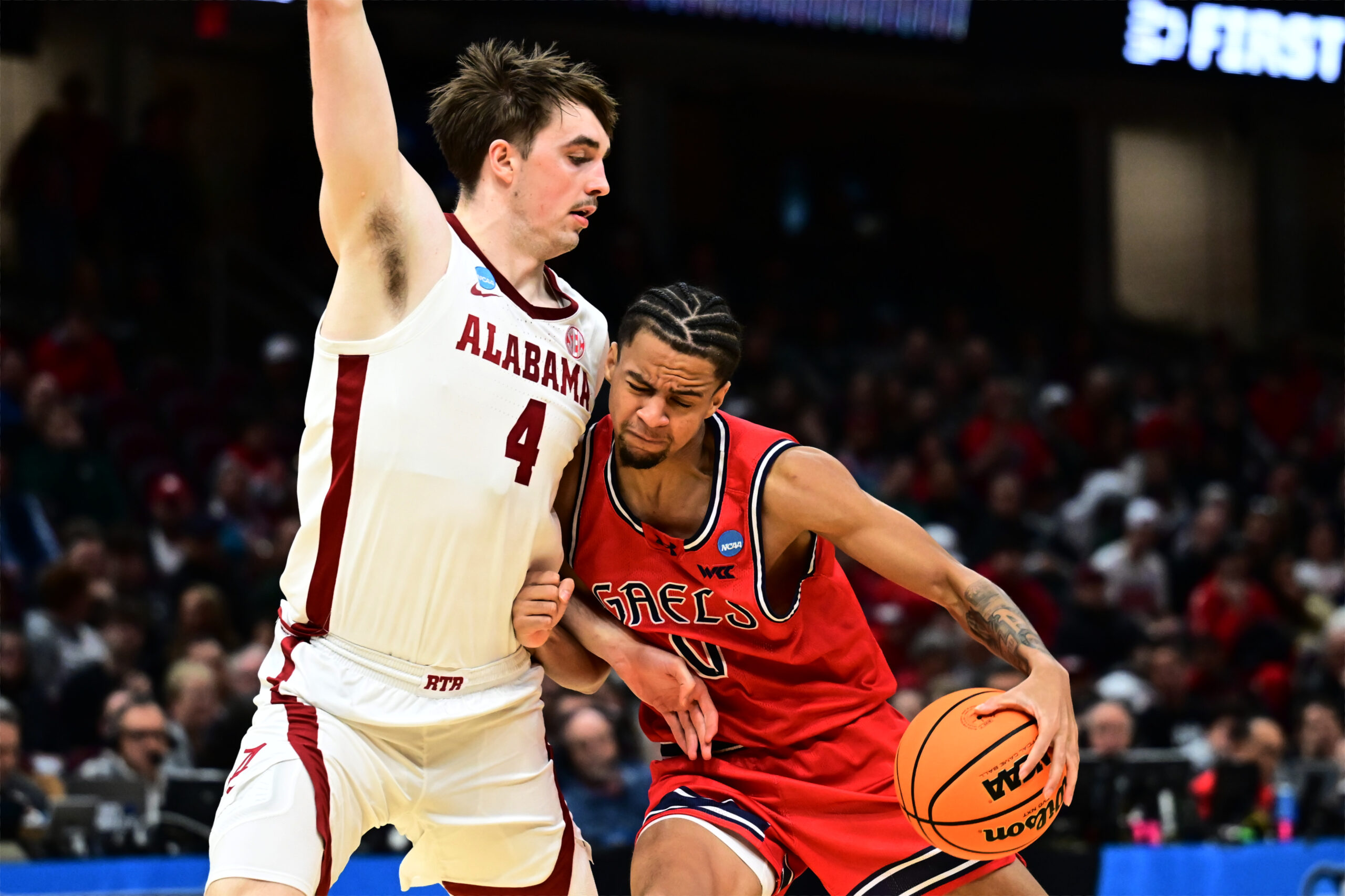 Mar 23, 2025; Cleveland, OH, USA; St. Mary's Gaels guard Mikey Lewis (0) plays the ball defended by Alabama Crimson Tide forward Grant Nelson (4) in the second half  during the NCAA Tournament Second Round at Rocket Arena. Mandatory Credit: Ken Blaze-Imagn Images