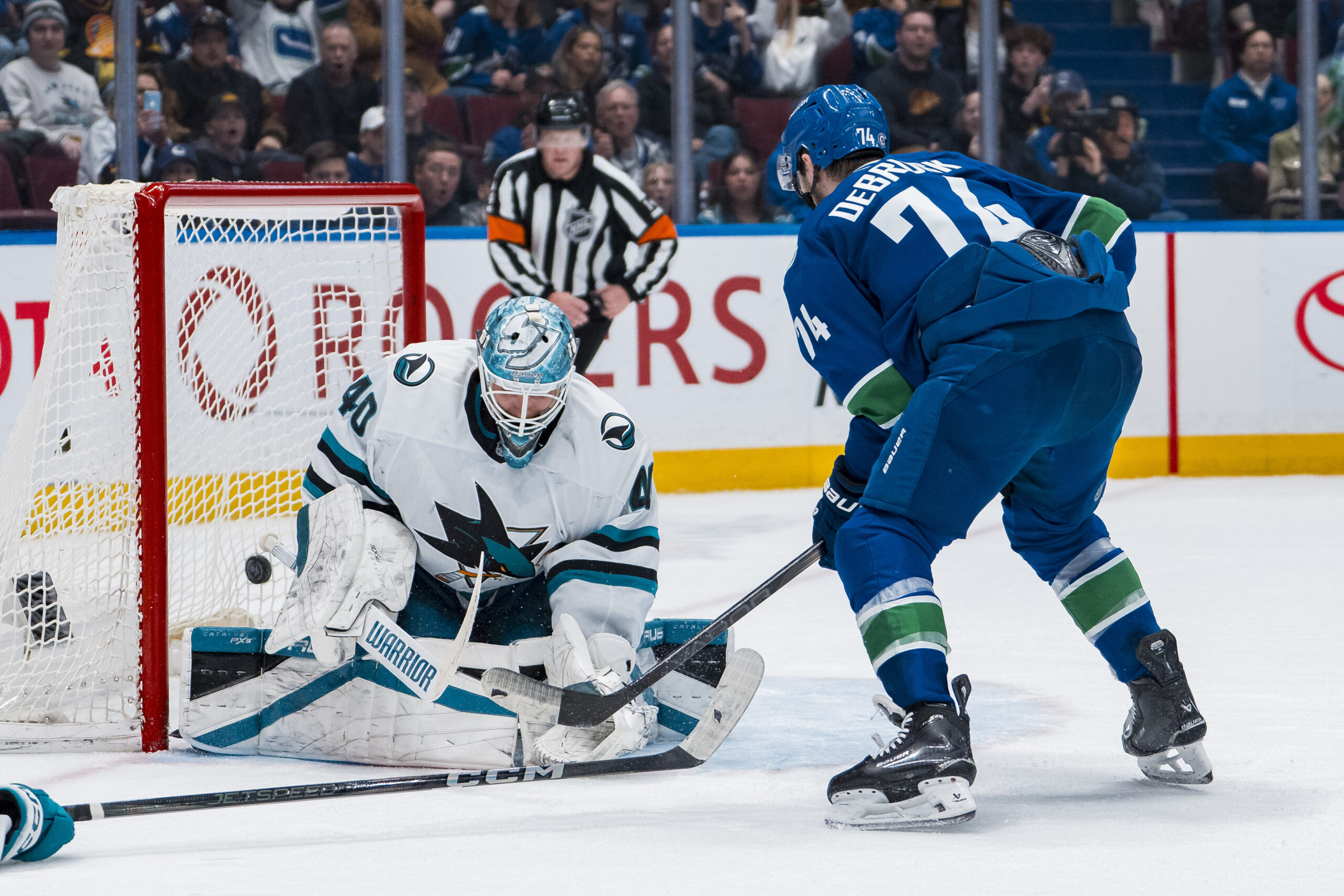 Apr 14, 2025; Vancouver, British Columbia, CAN; Vancouver Canucks forward Jake DeBrusk (74) scores on San Jose Sharks goalie Alexandar Georgiev (40) in overtime at Rogers Arena. Mandatory Credit: Bob Frid-Imagn Images