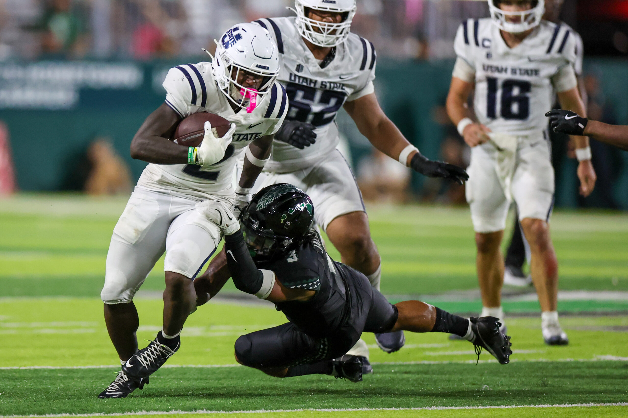 Oct 11, 2025; Honolulu, Hawaii, USA; Hawaii Rainbow Warriors linebacker Jalen Smith (3) tries to pull down Utah State Aggies running back Miles Davis (2) during the second half at Clarence T.C. Ching Athletics Complex. Mandatory Credit: Marco Garcia-Imagn Images