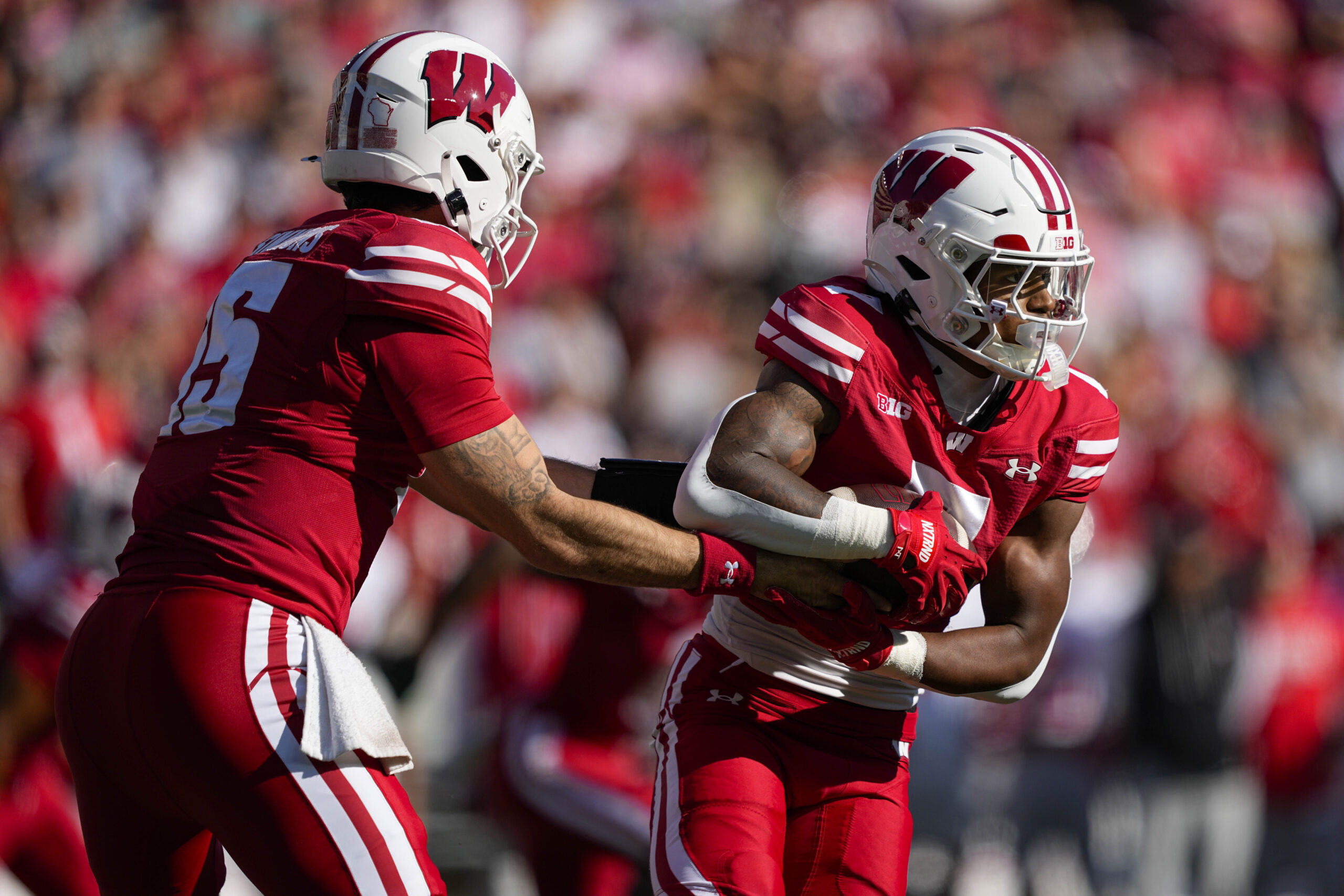 Oct 18, 2025; Madison, Wisconsin, USA; Wisconsin Badgers quarterback Hunter Simmons (15) hands the football off to running back Dilin Jones (7) during the game against the Ohio State Buckeyes at Camp Randall Stadium. Mandatory Credit: Jeff Hanisch-Imagn Images