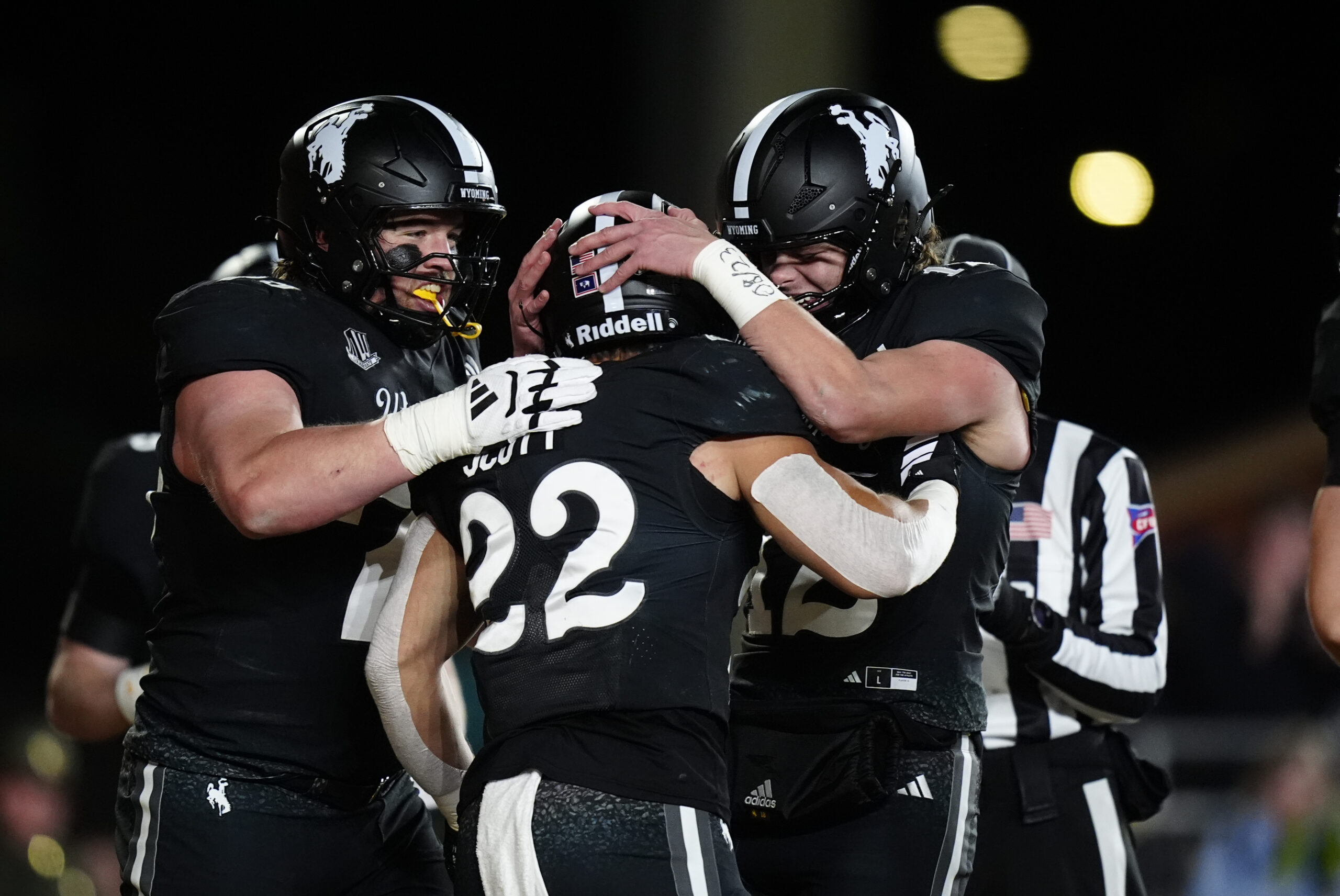 Oct 25, 2025; Laramie, Wyoming, USA; Wyoming Cowboys running back Sam Scott (22) celebrates his touchdown with quarterback Kaden Anderson (12) and offensive guard Wes King (78) in the second half against the Colorado State Rams at Jonah Field at War Memorial Stadium. Mandatory Credit: Ron Chenoy-Imagn Images