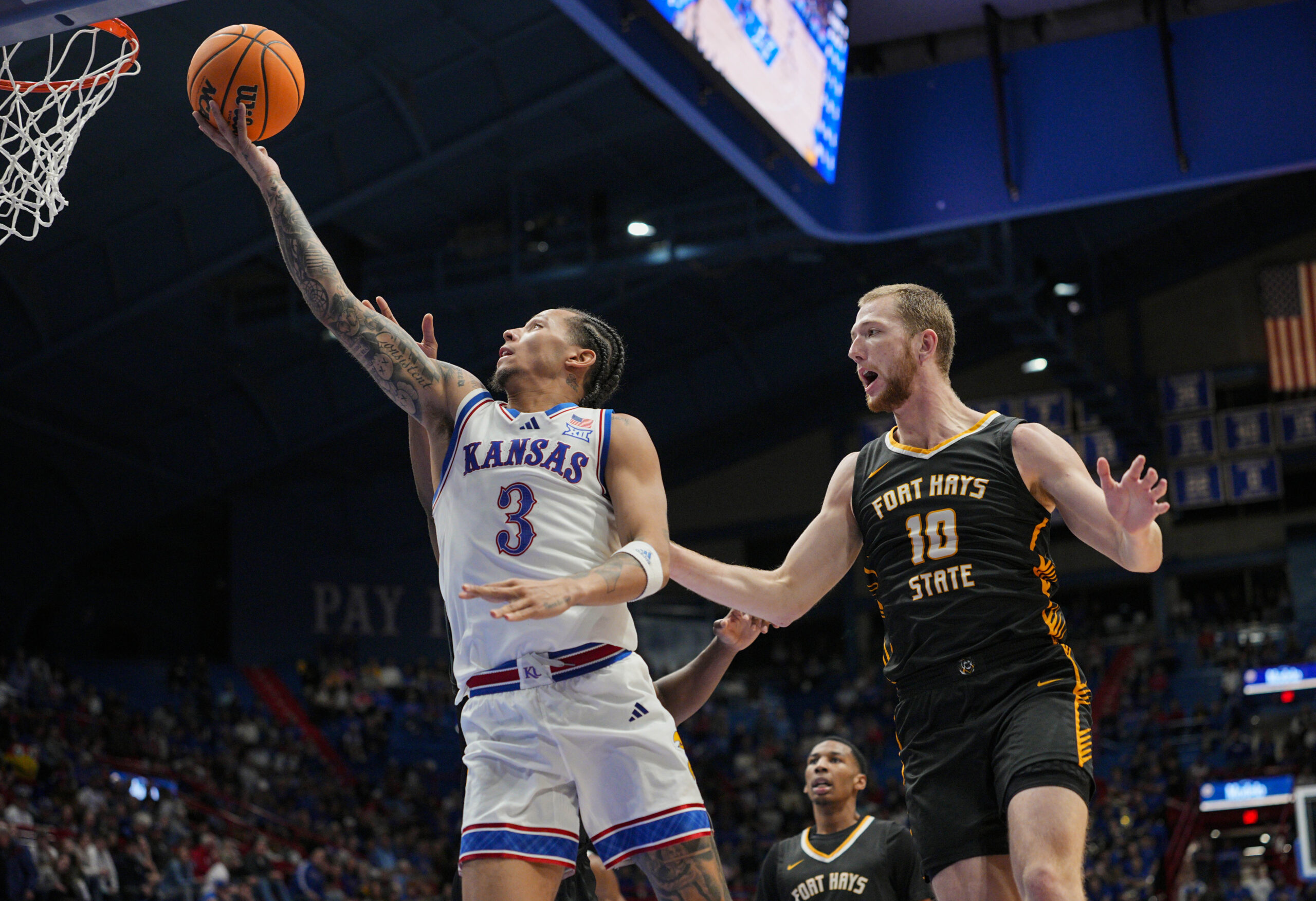 Oct 28, 2025; Lawrence, KS, USA; Kansas Jayhawks guard Tre White (3) shoots against Fort Hays State Tigers guard Blake Danitschek (10) during the second half at Allen Fieldhouse. Mandatory Credit: Jay Biggerstaff-Imagn Images