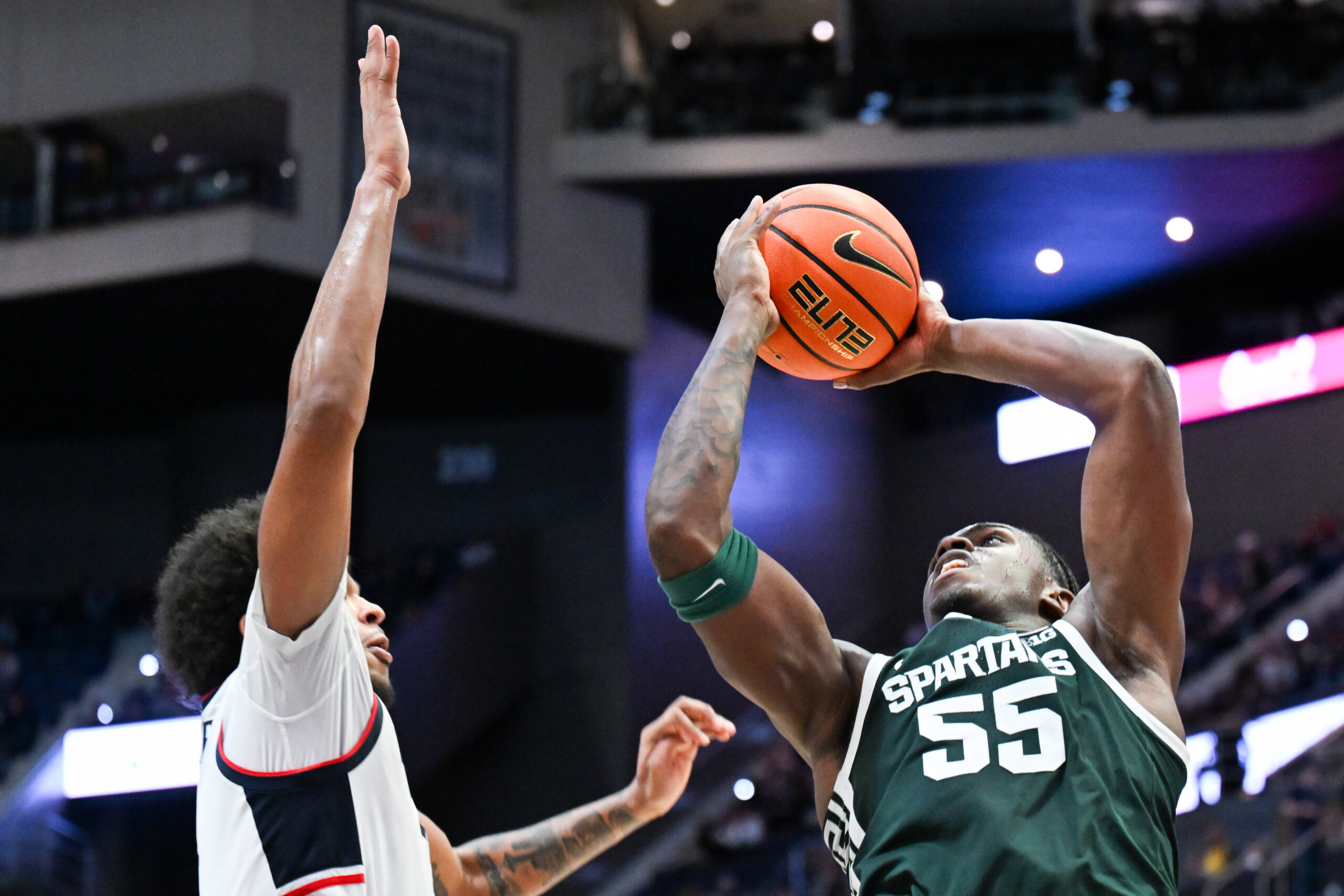 Oct 28, 2025; Hartford, CT, USA; Michigan State Spartans forward Coen Carr (55) shoots the ball against Connecticut Huskies forward Jayden Ross (23) during the second half at PeoplesBank Arena. Mandatory Credit: Mark Smith-Imagn Images