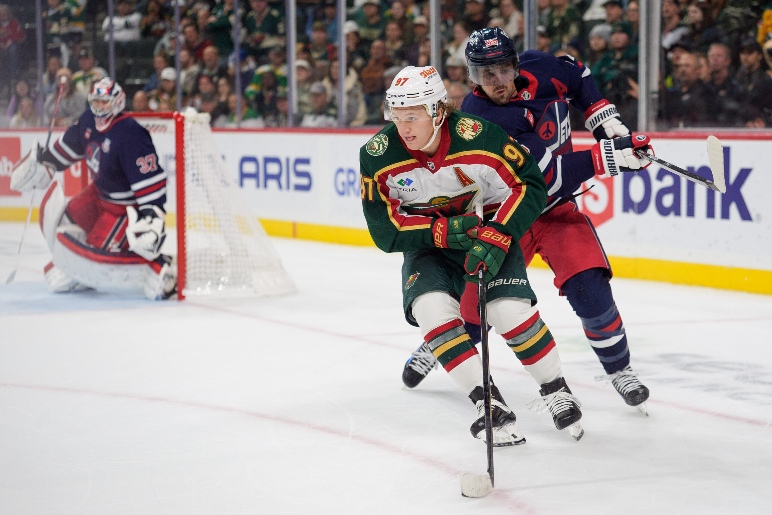 Oct 28, 2025; Saint Paul, Minnesota, USA; Minnesota Wild left wing Kirill Kaprizov (97) carries the puck while being stick checked by Winnipeg Jets center Mark Scheifele (55) in overtime at Grand Casino Arena. Mandatory Credit: Matt Blewett-Imagn Images