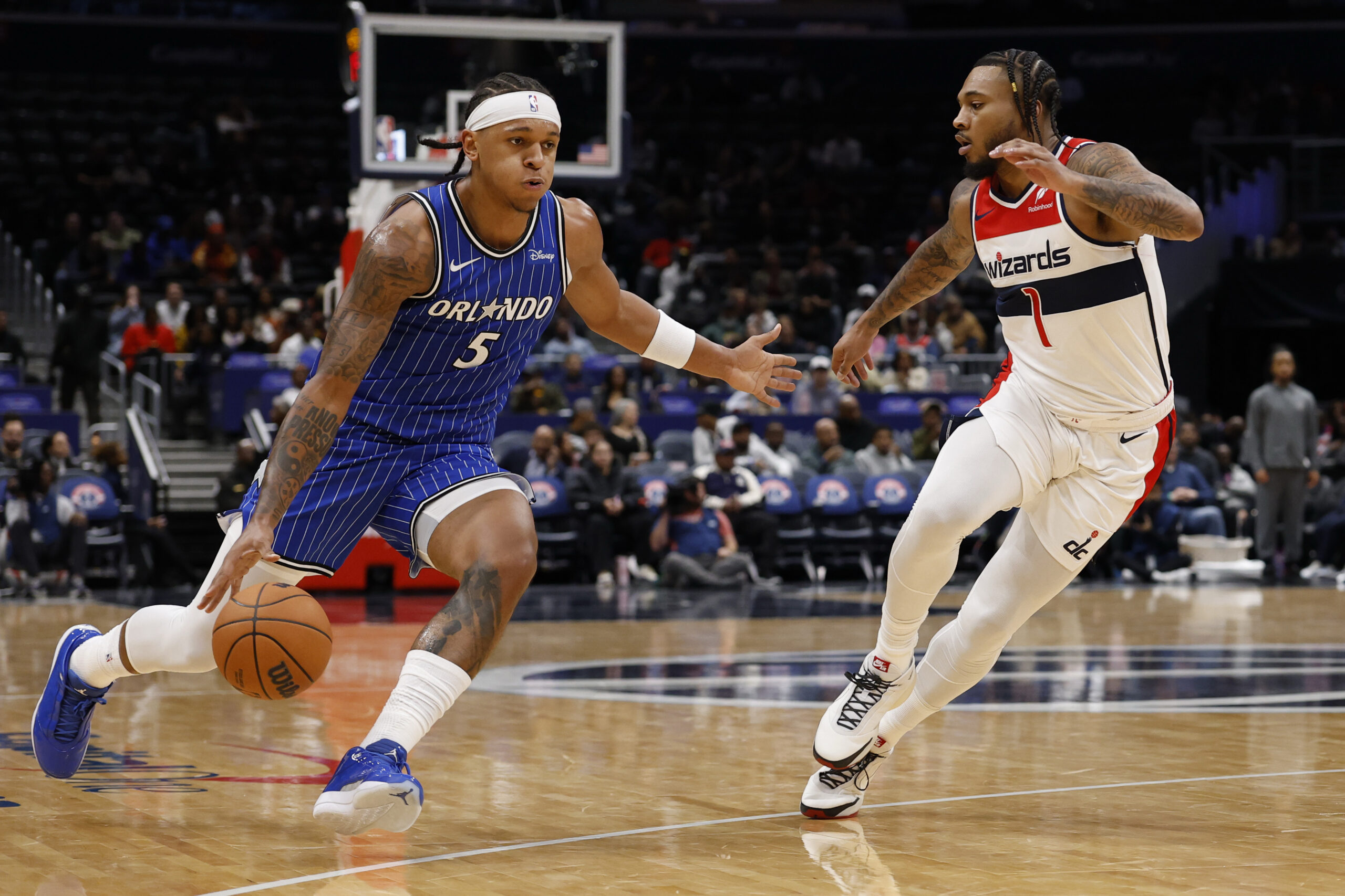 Nov 1, 2025; Washington, District of Columbia, USA; Orlando Magic forward Paolo Banchero (5) drives to the basket as Washington Wizards forward Cam Whitmore (1) defends in the first half at Capital One Arena. Mandatory Credit: Geoff Burke-Imagn Images