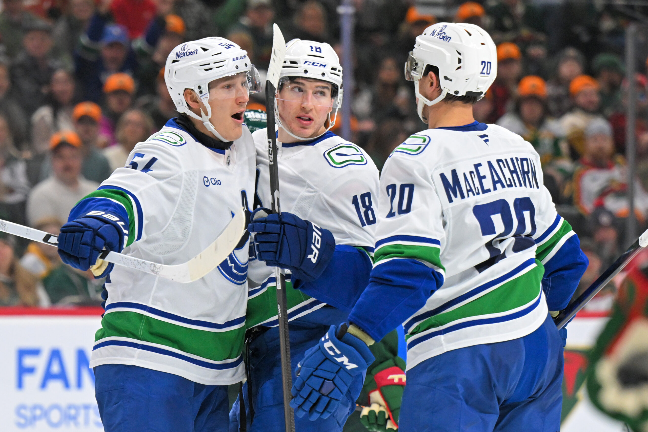 Nov 1, 2025; Saint Paul, Minnesota, USA; Vancouver Canucks forward Drew O'Connor (18) celebrates his goal against the Minnesota Wild with forward Aatu Raty (54) and forward Mackenzie MacEachern during the third period at Grand Casino Arena. Mandatory Credit: Nick Wosika-Imagn Images