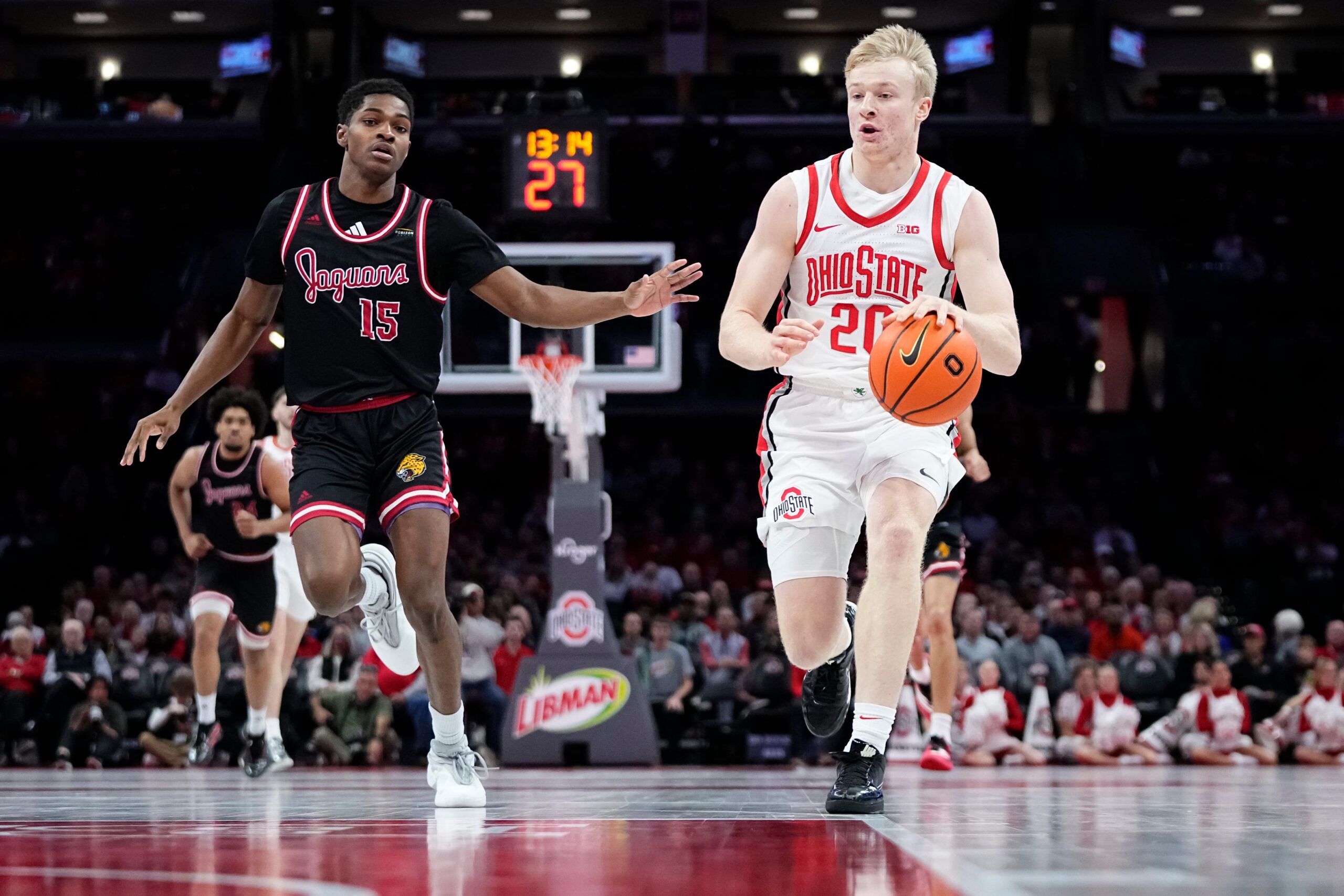 Ohio State Buckeyes forward Colin White (20) dribbles ahead of IU Indy Jaguars guard Matt Compas (15) during the NCAA men's basketball game at Value City Arena in Columbus on Nov. 3, 2025. Ohio State won the season opener 118-102.