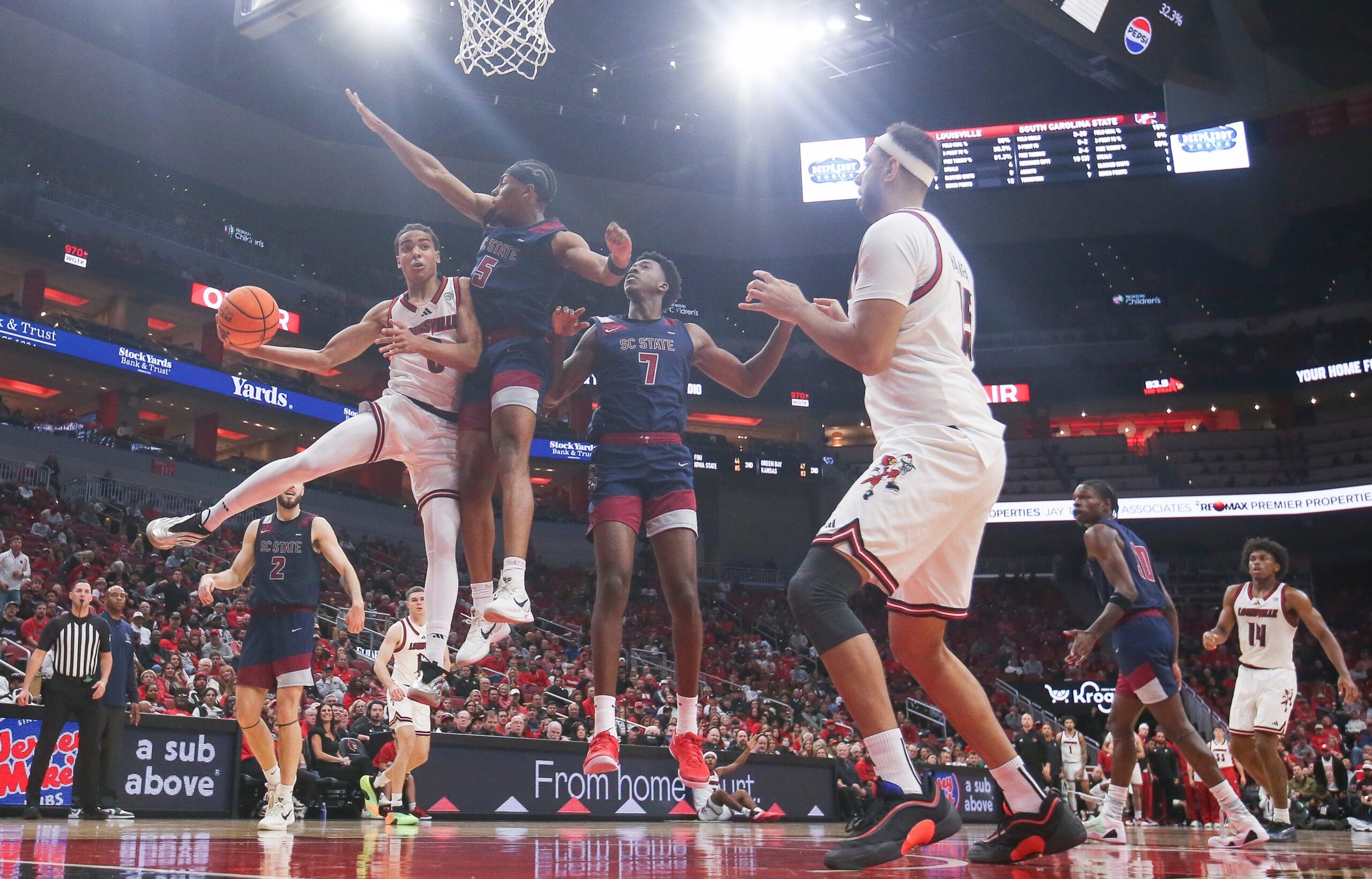 Louisville Cardinals guard Mikel Brown Jr. (0) passes around South Carolina State Bulldogs guard Jr. Owen Bronston (5) as the Cards led 59-15 at the half at the KFC Yum! Center Monday night, Nov. 3, 2025.