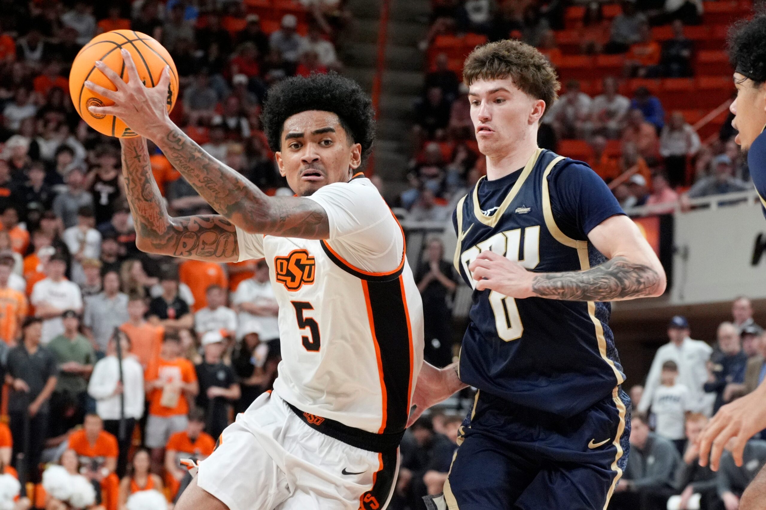 Oklahoma State Cowboys guard Vyctorius Miller (5) drives past Oral Roberts Golden Eagles guard Jack Turner (0) during an NCAA basketball game between the Oklahoma State University Cowboys (OSU) and Oral Roberts at Gallagher-Iba Arena in Stillwater, Okla., Tuesday, Nov. 4, 2025. Oklahoma State on 95-71.