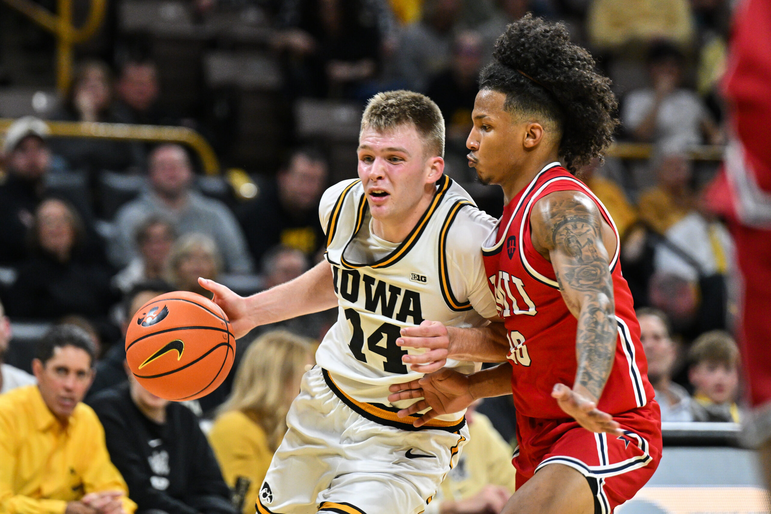 Nov 4, 2025; Iowa City, Iowa, USA; Iowa Hawkeyes guard Bennett Stirtz (14) controls the ball as Robert Morris Colonials guard Albert Vargas (20) defends during the second half at Carver-Hawkeye Arena. Mandatory Credit: Jeffrey Becker-Imagn Images