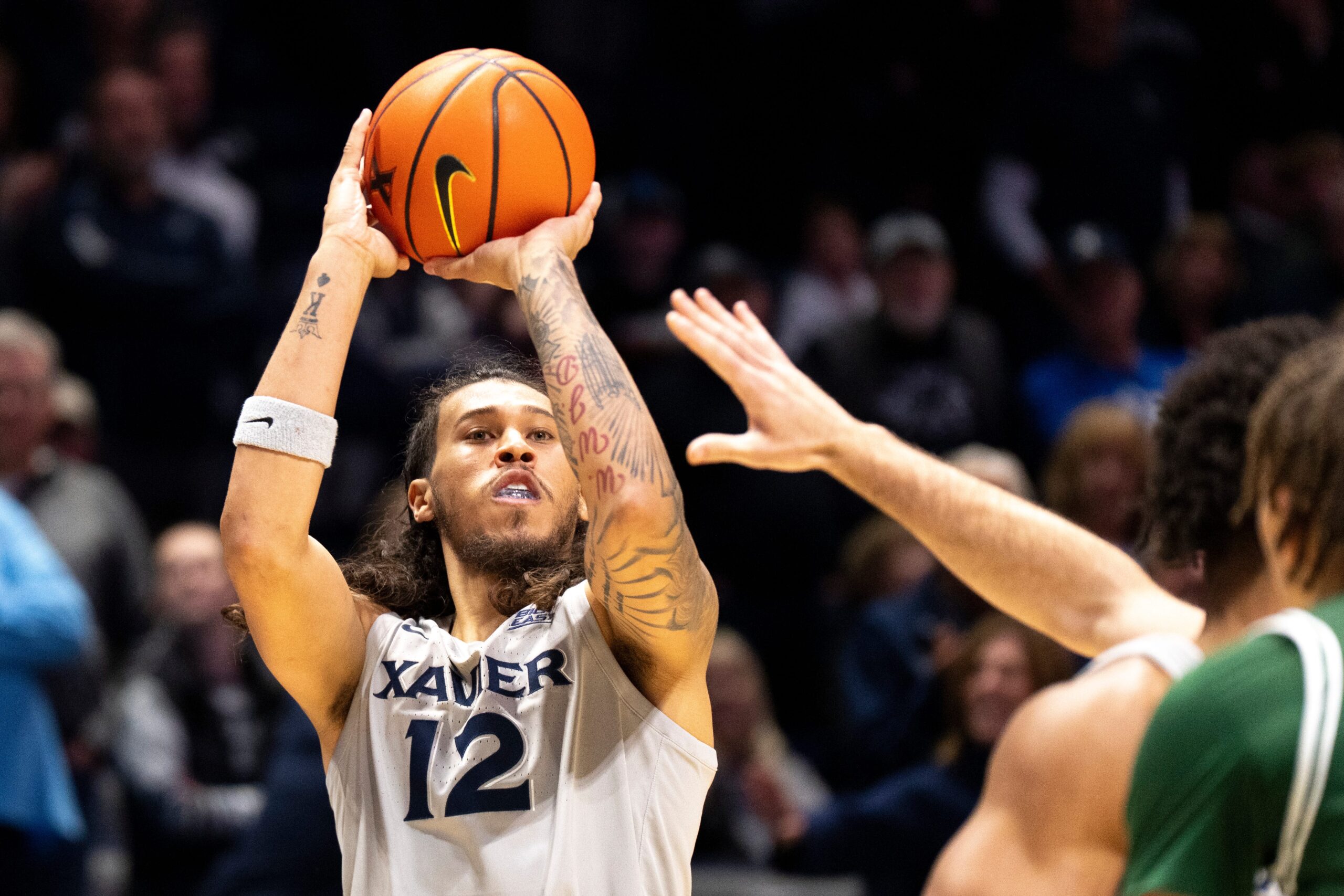Xavier Musketeers forward Tre Carroll (12) hits a 3-point shot in the first half of the NCAA game against the Le Moyne Dolphins at the Cintas Center in Cincinnati on Nov. 6, 2025.