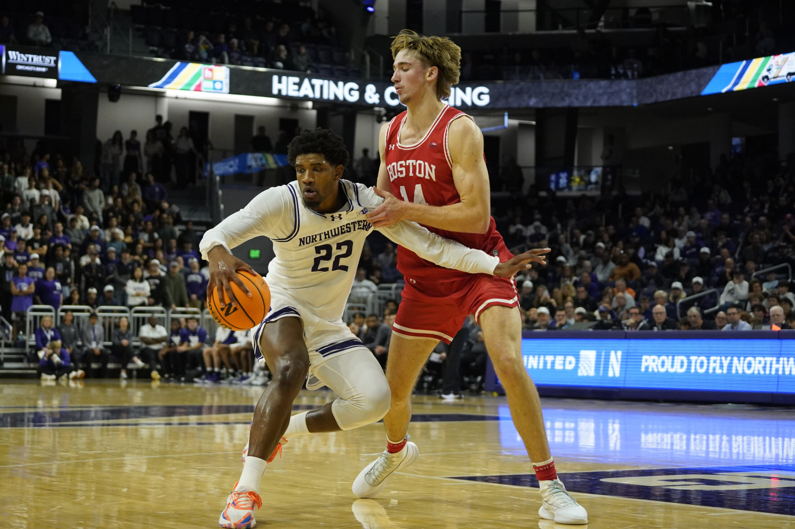 Nov 7, 2025; Evanston, Illinois, USA; Boston University Terriers forward Ben Defty (14) defends Northwestern Wildcats forward Arrinten Page (22) during the first half at Welsh-Ryan Arena. Mandatory Credit: David Banks-Imagn Images