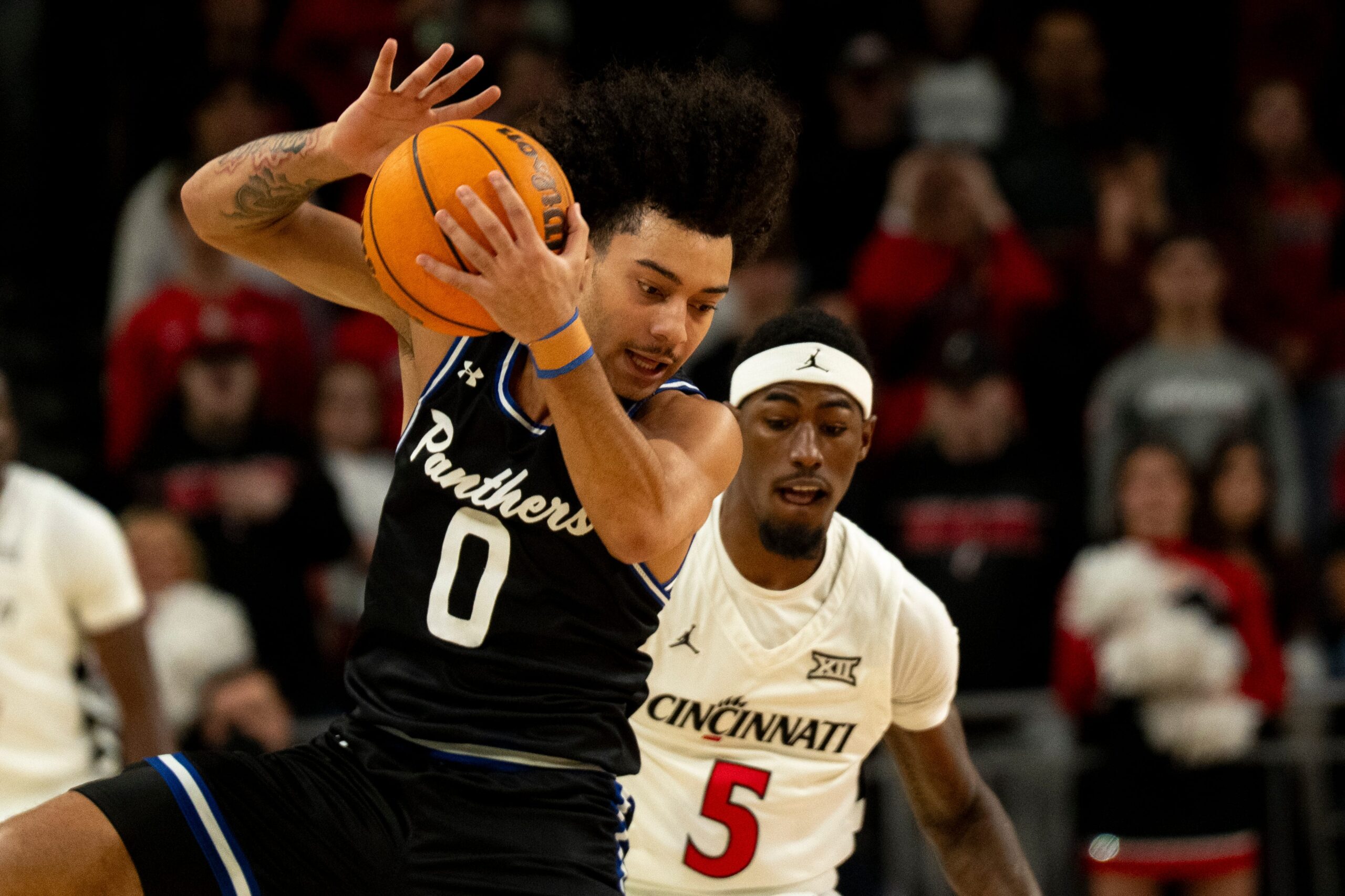 Georgia State Panthers guard Micah Tucker (0) catches a pass as Cincinnati Bearcats guard Sencire Harris (5) guards him in the first half of the NCAA basketball game at Fifth Third Arena in Cincinnati on Nov. 7, 2025.