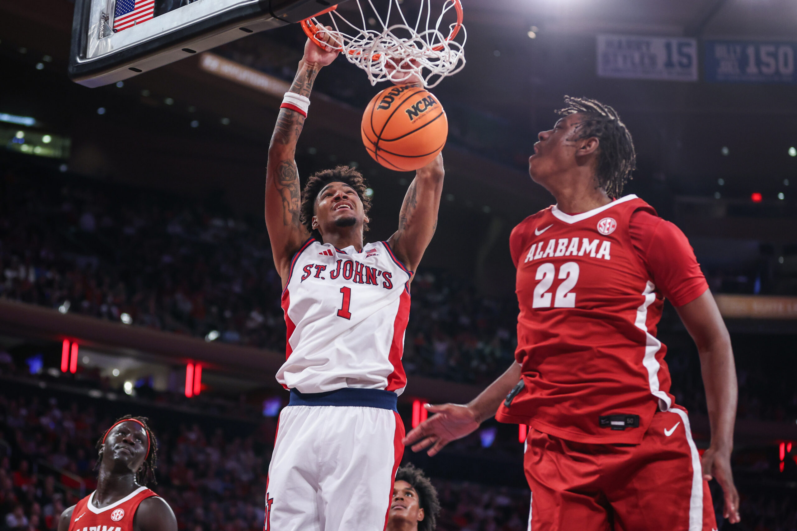 Nov 8, 2025; New York, New York, USA; St. John's Red Storm forward Dillon Mitchell (1) dunks past Alabama Crimson Tide forward Aiden Sherrell (22) in the second half at Madison Square Garden. Mandatory Credit: Wendell Cruz-Imagn Images