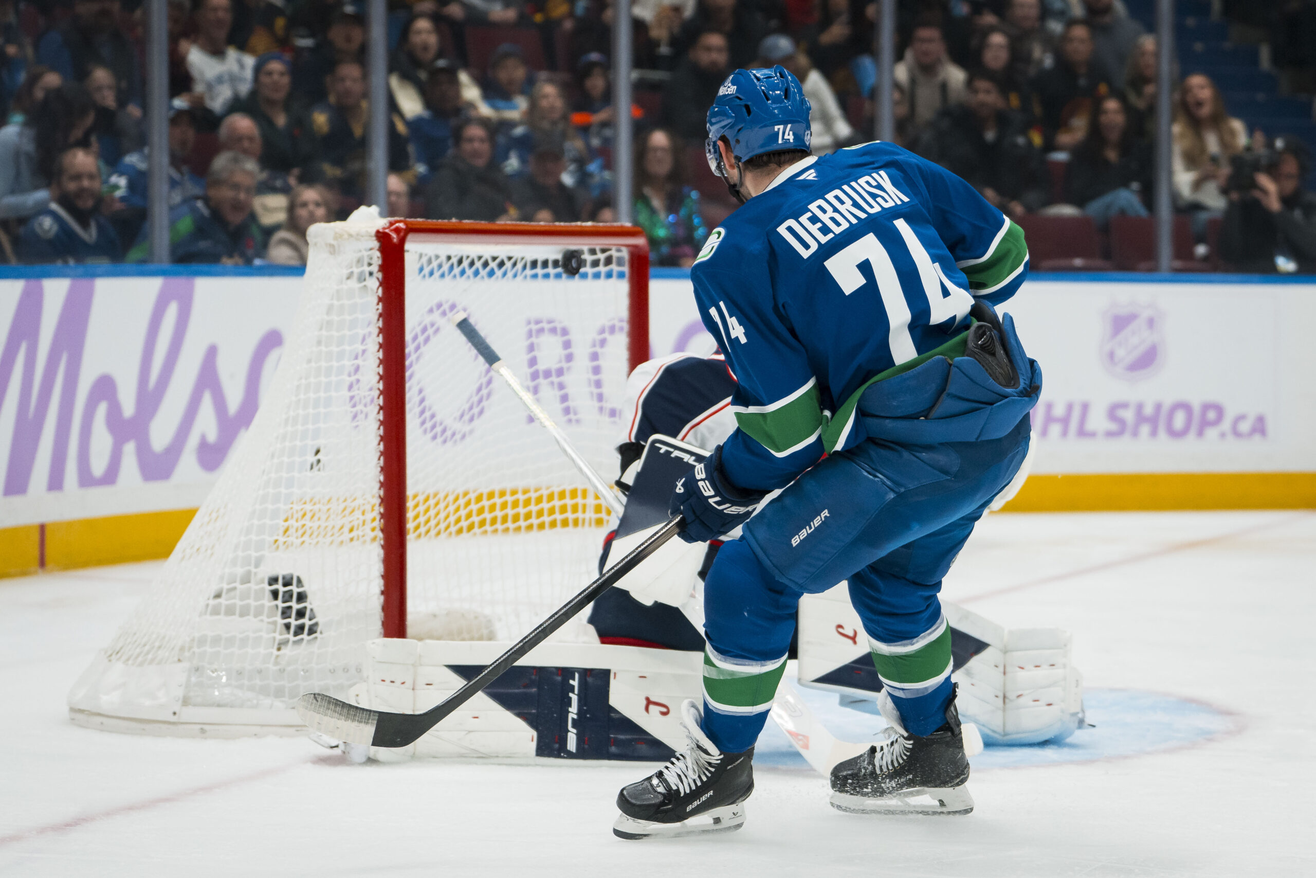 Nov 8, 2025; Vancouver, British Columbia, CAN; Vancouver Canucks forward Jake DeBrusk (74) scores on Columbus Blue Jackets goalie Elvis Merzlikins (90) in the second period at Rogers Arena. Mandatory Credit: Bob Frid-Imagn Images