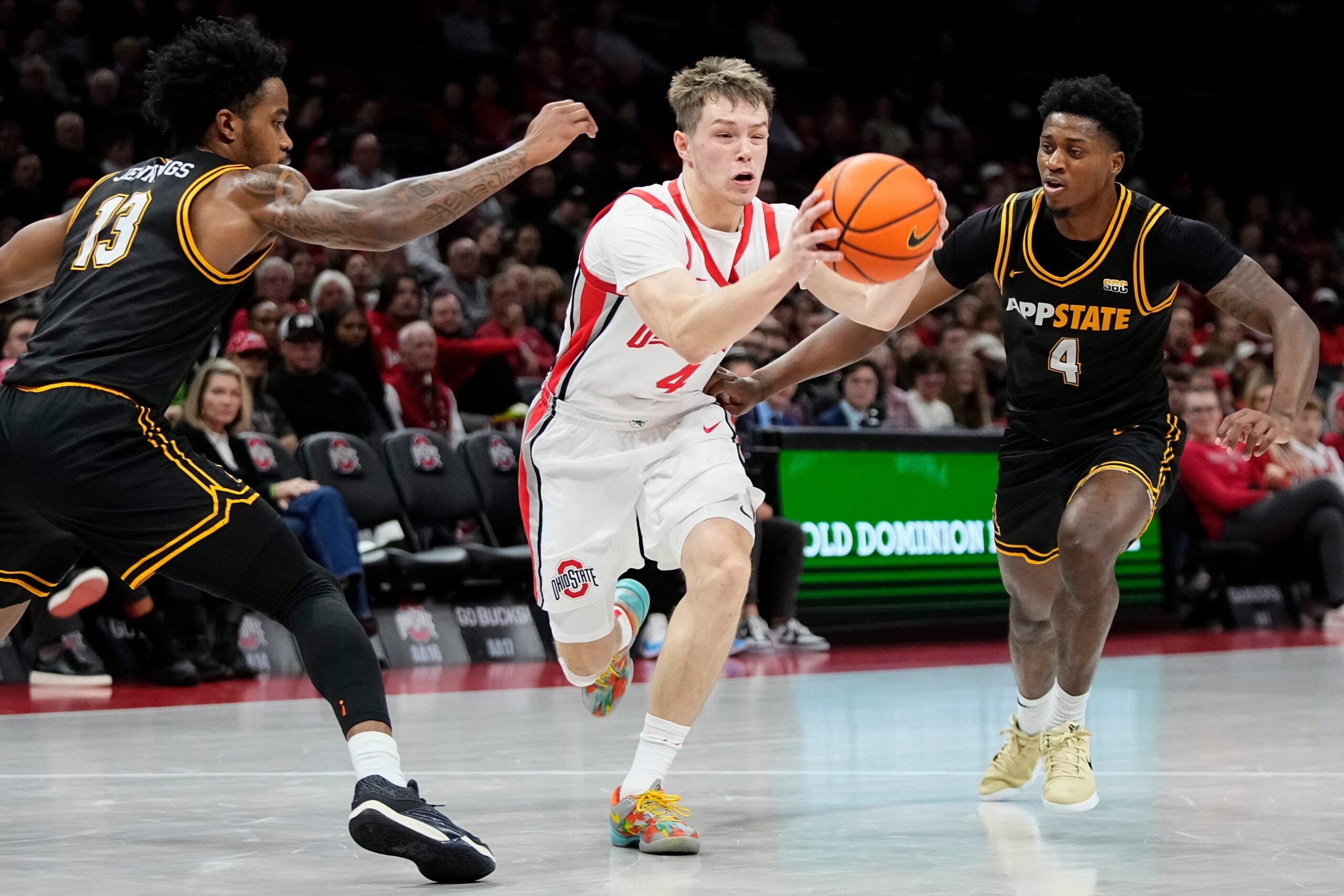 Ohio State Buckeyes guard Gabe Cupps (4) dribbles by Appalachian State Mountaineers guard Kasen Jennings (13) during the NCAA men's basketball game at Value City Arena in Columbus on Nov. 11, 2025. Ohio State won 75-53.