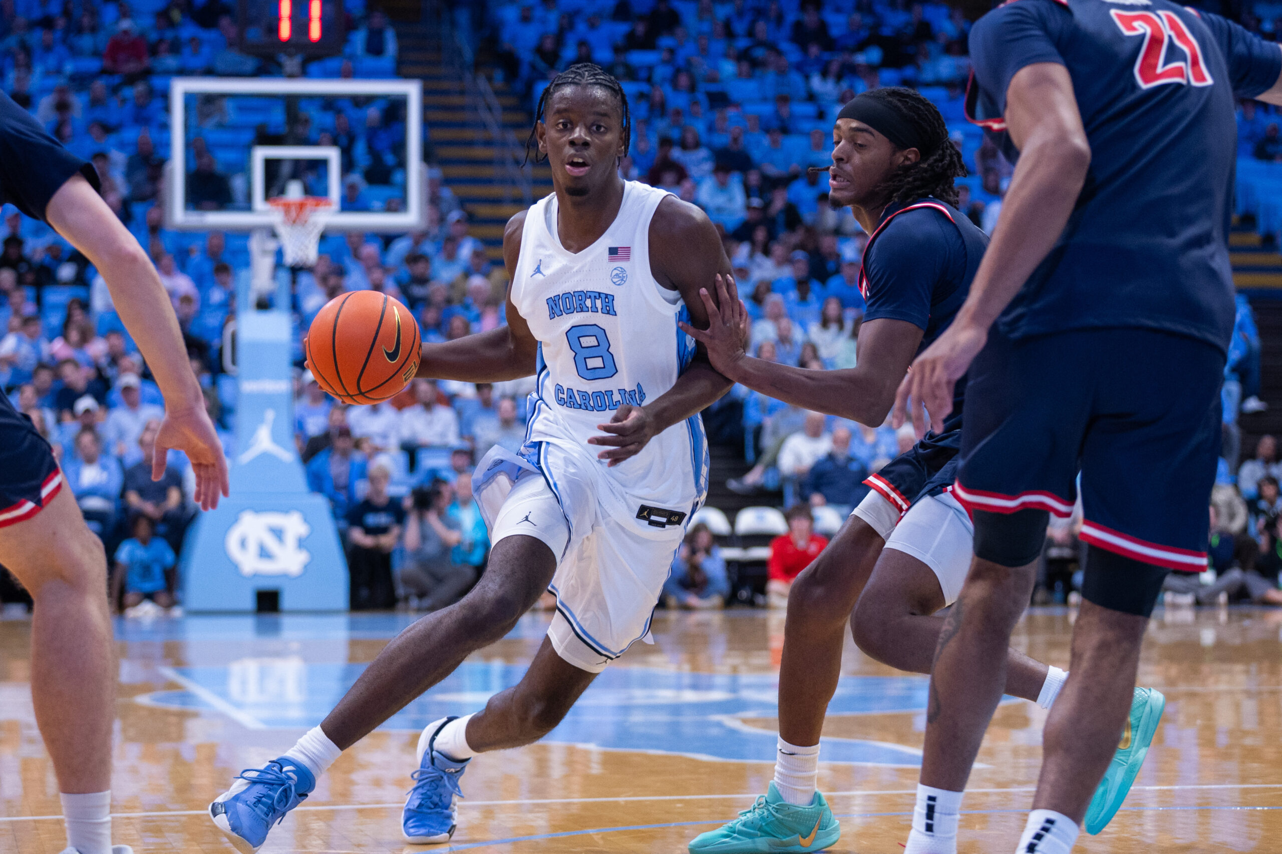 Nov 11, 2025; Chapel Hill, North Carolina, USA; North Carolina Tar Heels forward Caleb Wilson (8) drives past Radford Highlanders guard Jr. Dennis Parker (11) during the second half at Dean E. Smith Center. Mandatory Credit: Scott Kinser-Imagn Images