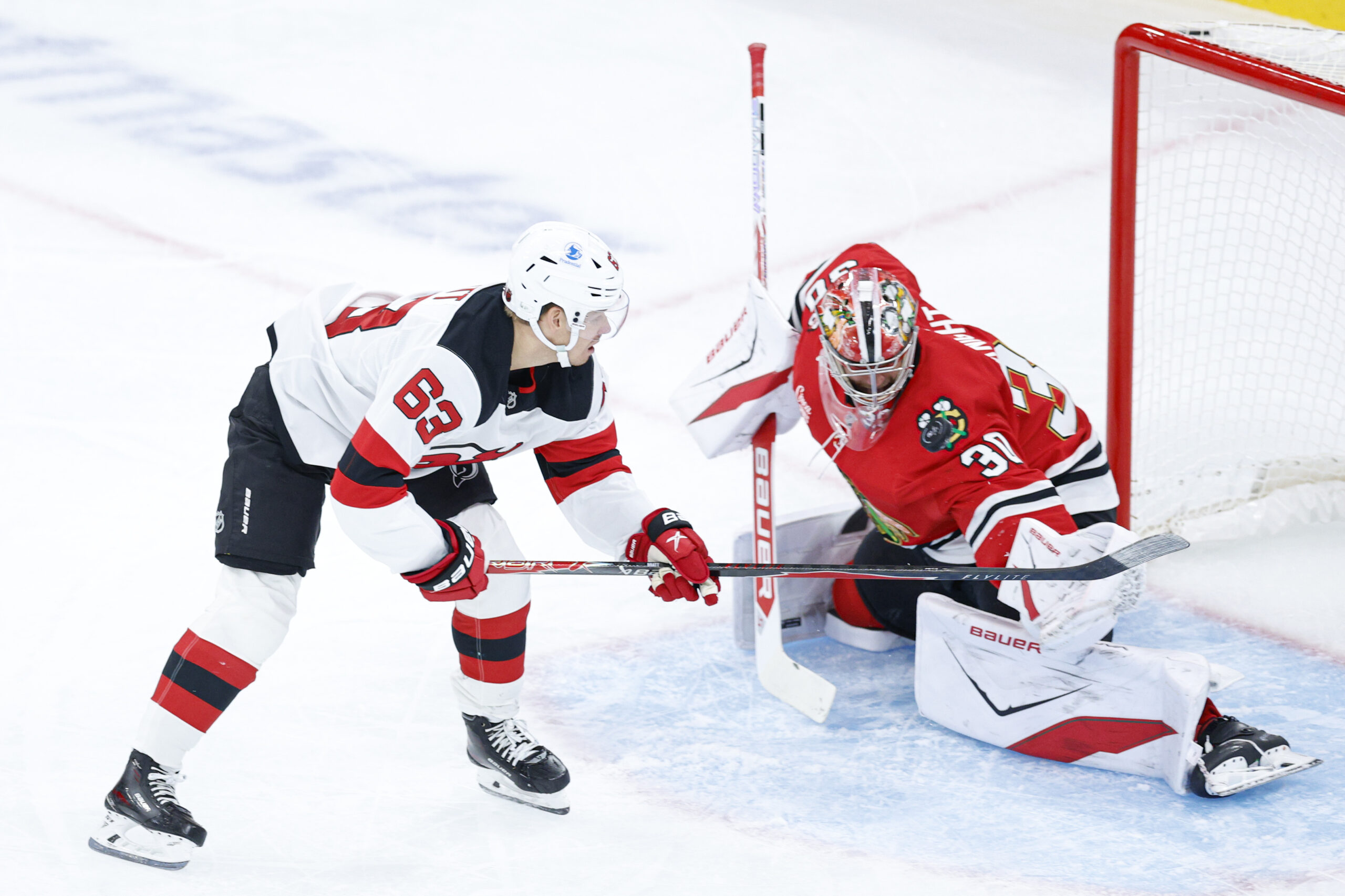 Nov 12, 2025; Chicago, Illinois, USA; Chicago Blackhawks goaltender Spencer Knight (30) defends against New Jersey Devils left wing Jesper Bratt (63) during the first period at United Center. Mandatory Credit: Kamil Krzaczynski-Imagn Images