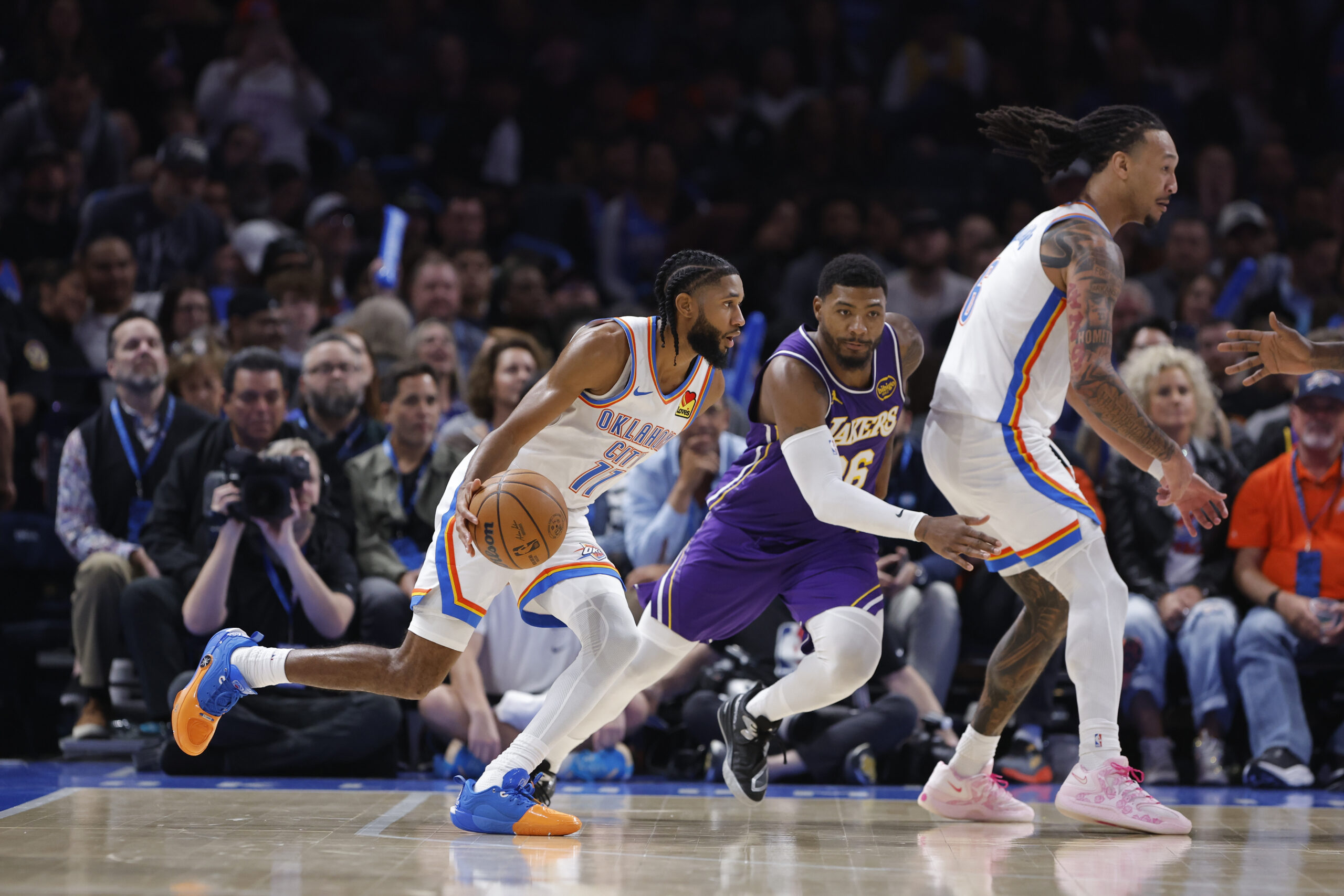 Nov 12, 2025; Oklahoma City, Oklahoma, USA; Oklahoma City Thunder guard Isaiah Joe (11) drives to the basket beside Los Angeles Lakers guard Marcus Smart (36) during the fourth quarter at Paycom Center. Mandatory Credit: Alonzo Adams-Imagn Images