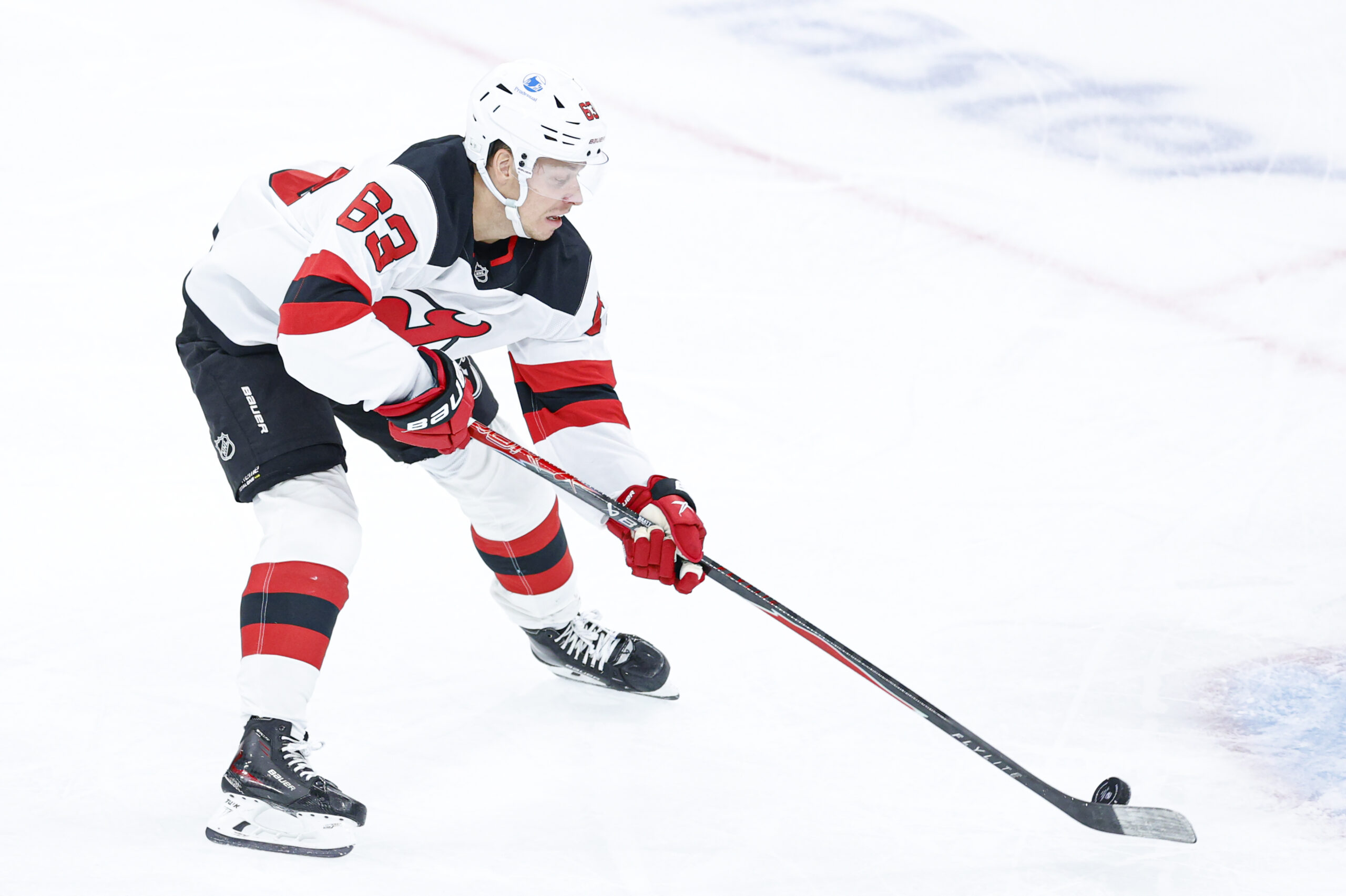 Nov 12, 2025; Chicago, Illinois, USA; New Jersey Devils left wing Jesper Bratt (63) controls the puck against the Chicago Blackhawks during the first period at United Center. Mandatory Credit: Kamil Krzaczynski-Imagn Images