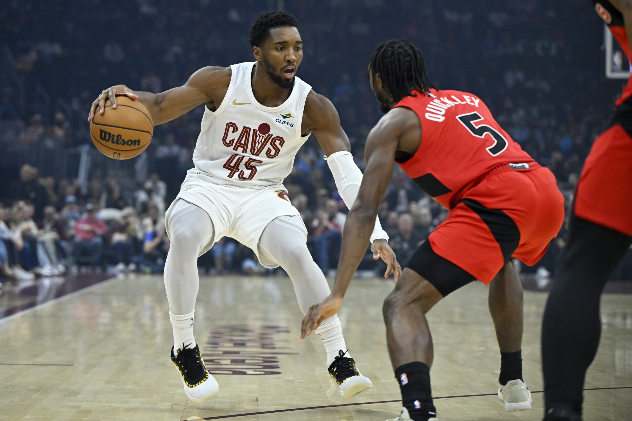 Nov 13, 2025; Cleveland, Ohio, USA; Cleveland Cavaliers guard Donovan Mitchell (45) dribbles beside Toronto Raptors guard Immanuel Quickley (5) in the first quarter at Rocket Arena. Mandatory Credit: David Richard-Imagn Images