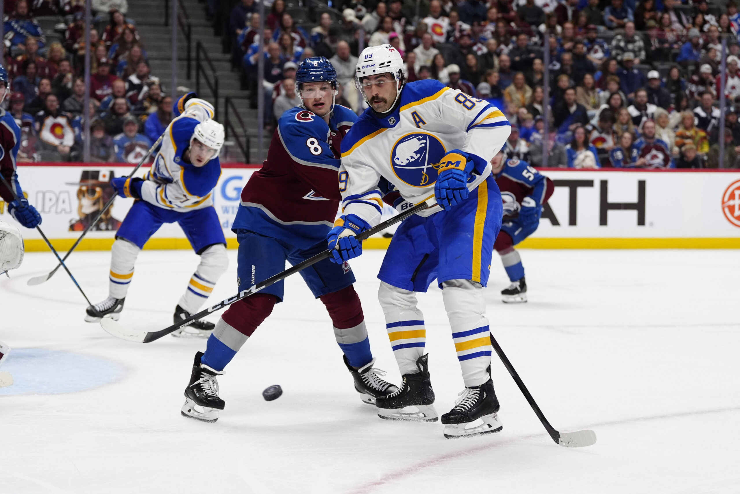 Nov 13, 2025; Denver, Colorado, USA; Buffalo Sabres right wing Alex Tuch (89) and Colorado Avalanche defenseman Cale Makar (8) battle for the puck in the third period at Ball Arena. Mandatory Credit: Ron Chenoy-Imagn Images