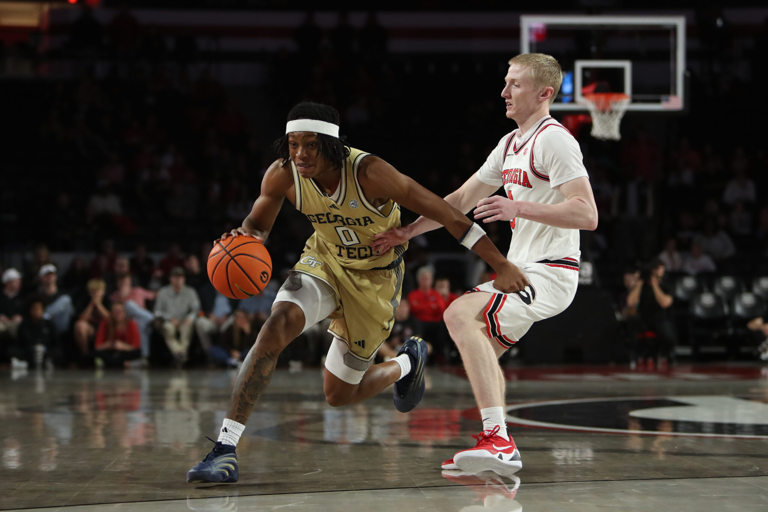 Nov 14, 2025; Athens, Georgia, USA; Georgia Tech Yellow Jackets guard Akai Fleming (0) dribbles past Georgia Bulldogs guard Blue Cain (0) during the second half at Stegeman Coliseum. Mandatory Credit: Mady Mertens-Imagn Images